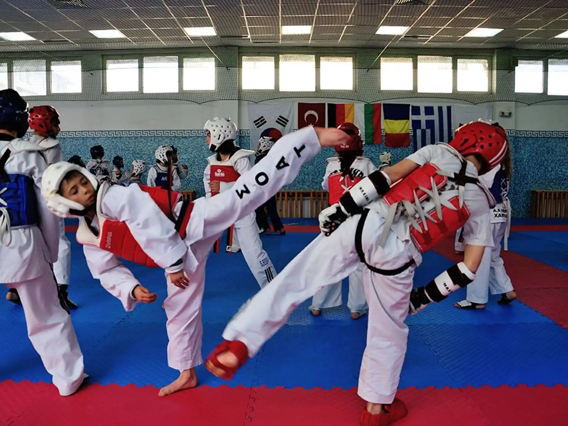 a group of people in white and red uniforms in a room with a wall of lights