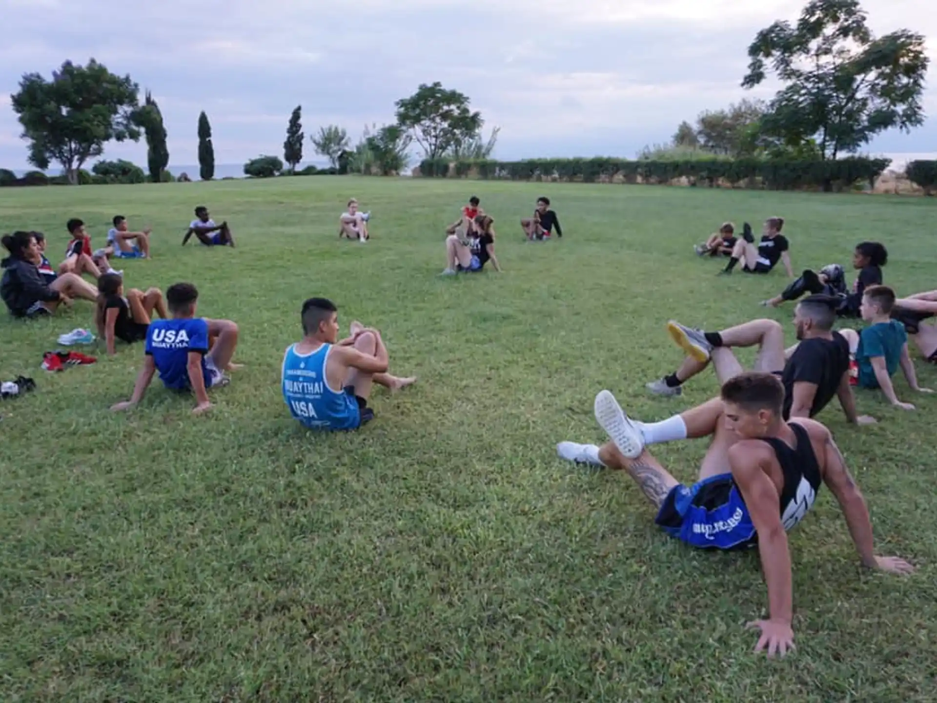 a group of people sitting on the grass