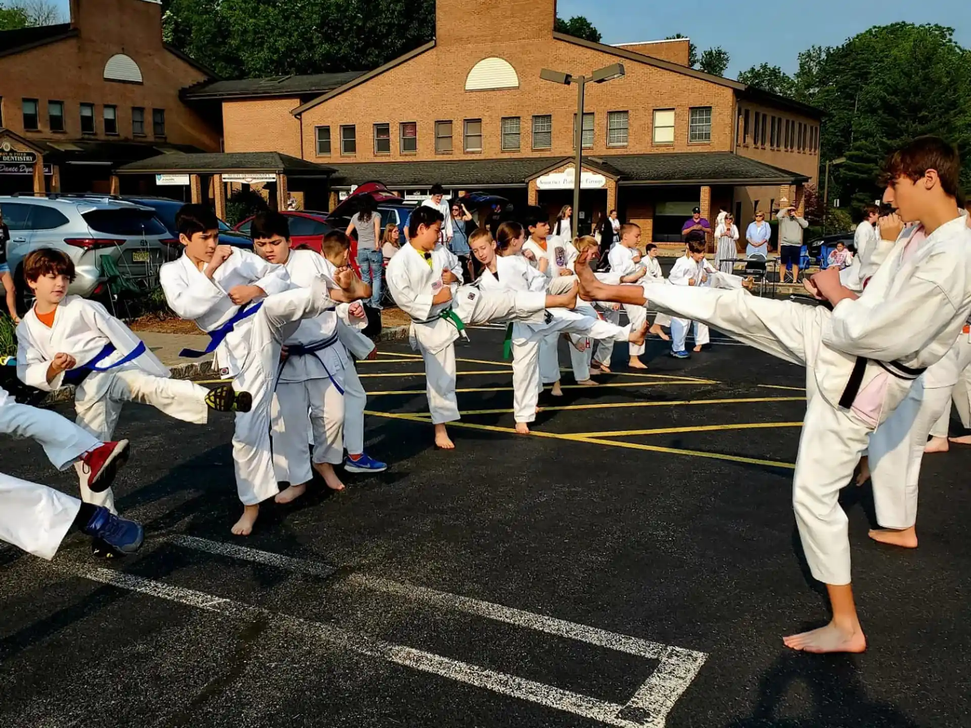 a group of people in white karate uniforms in a street