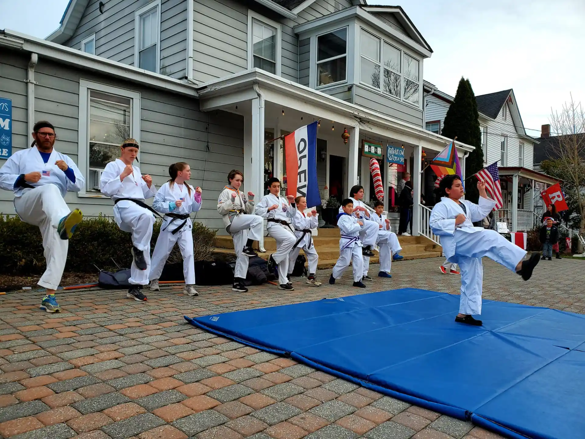 a group of people in white uniforms sitting on a bench in front of a building