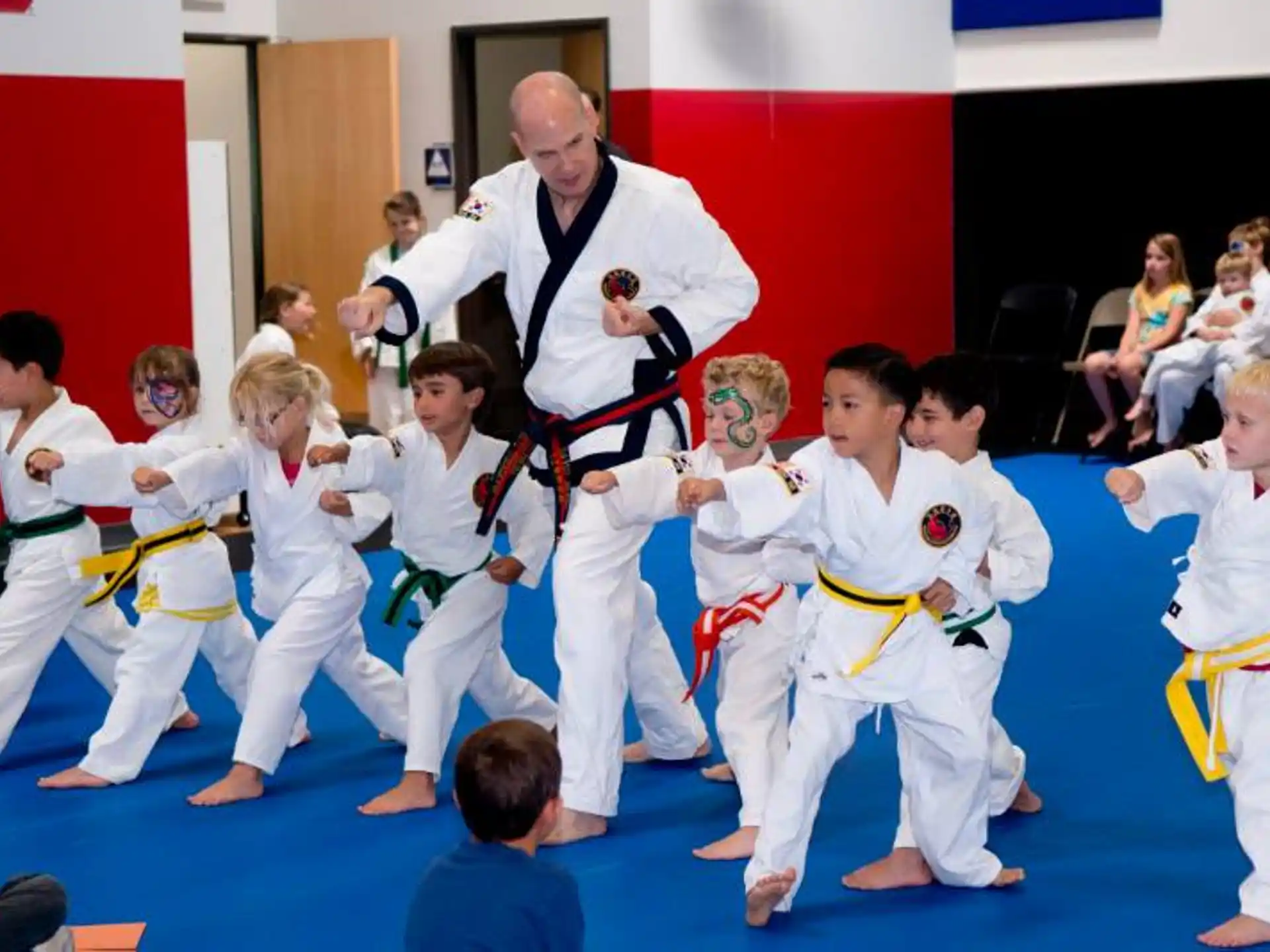 a person teaching children how to do martial arts