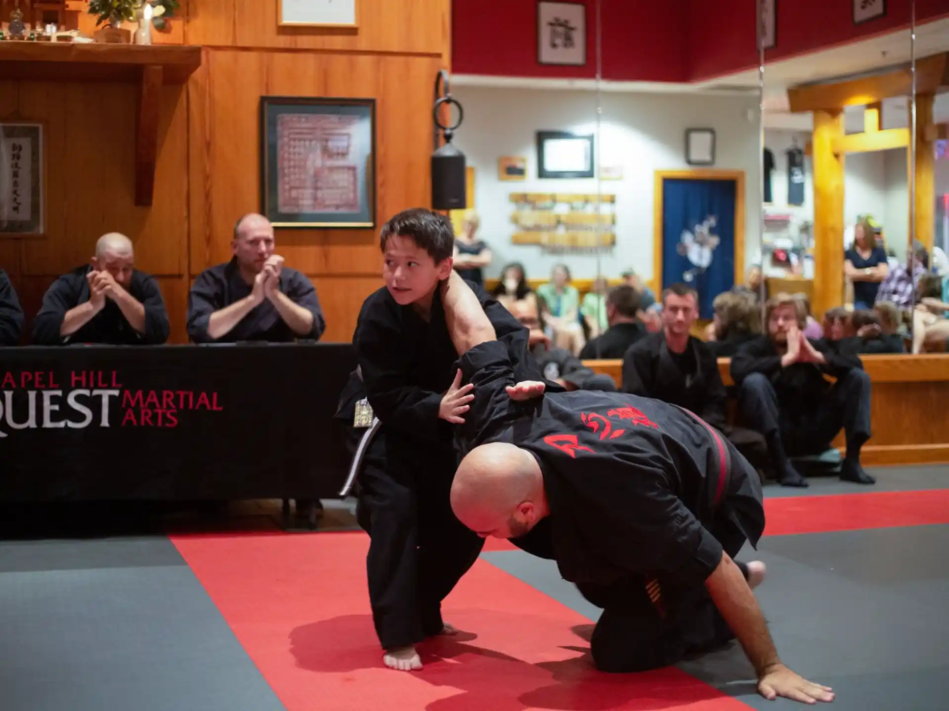 a person kicking another man in the face with a crowd watching