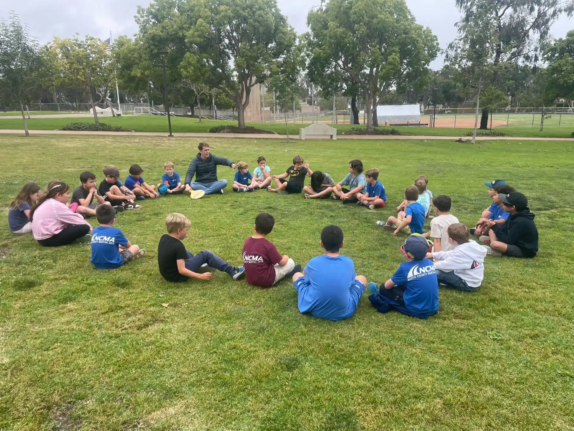 a group of people sitting on the grass
