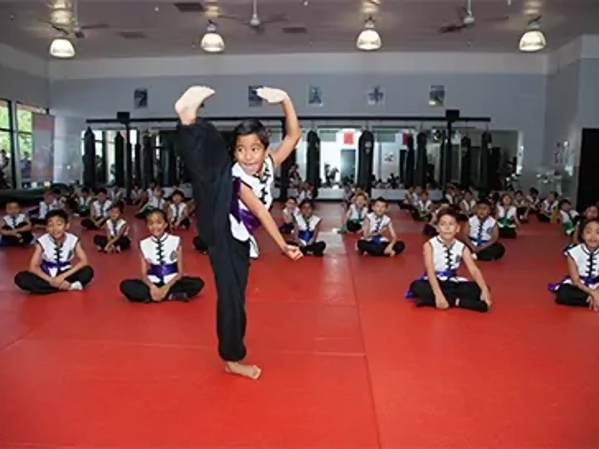 a group of people sitting on the floor with their arms up