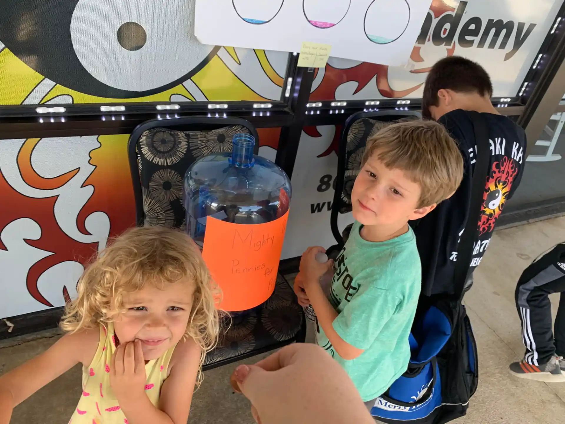 a group of kids sitting in a chair with a drink in a bucket