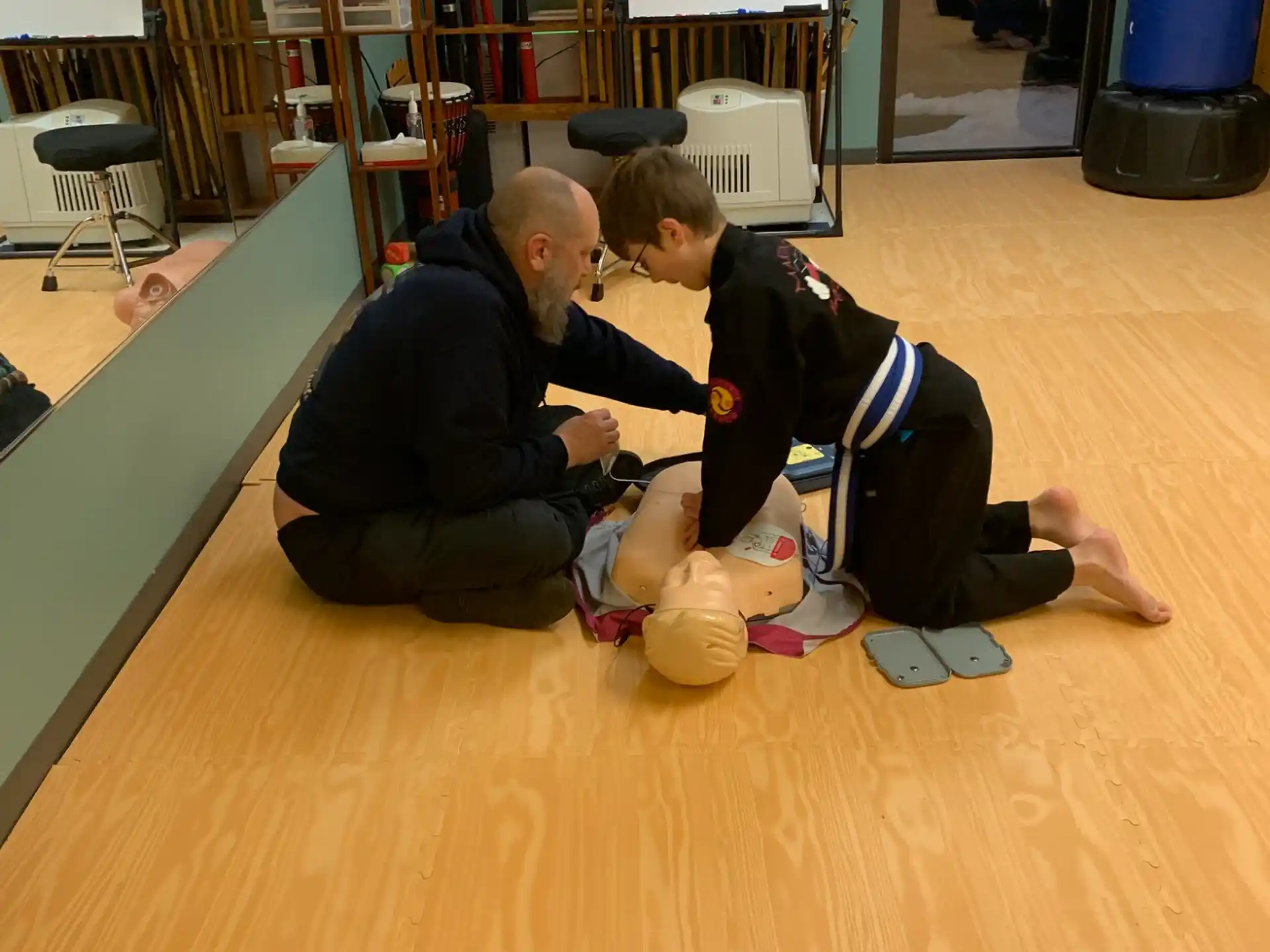 a person and a boy playing with a ball on a wood floor