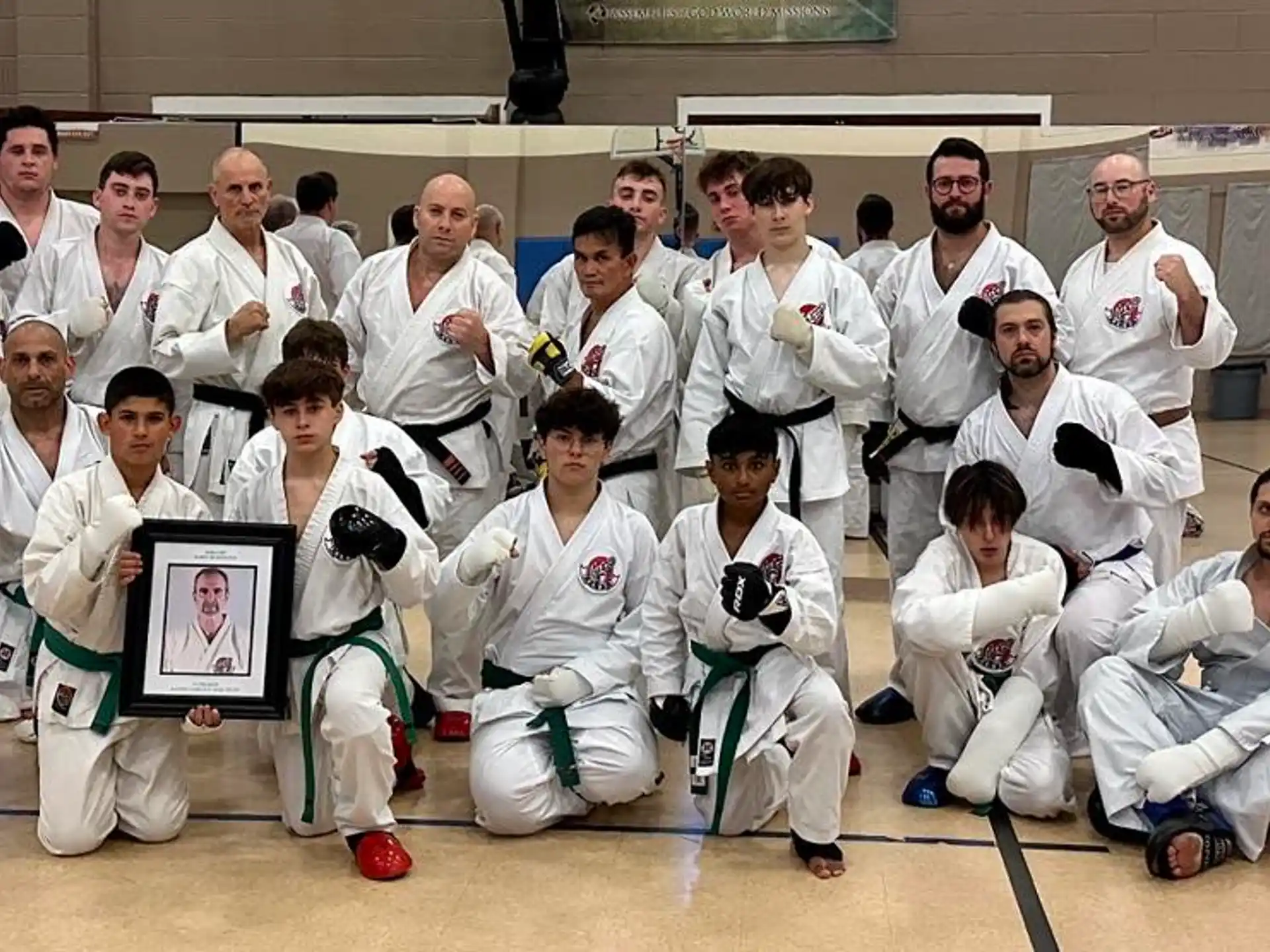 a group of people in white karate uniforms posing for a photo