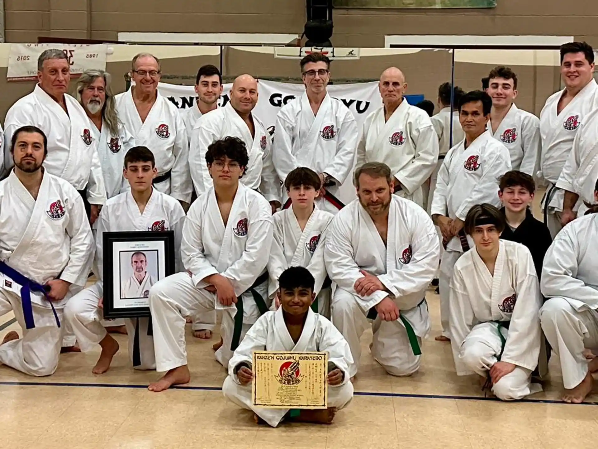 a group of people in white karate uniforms posing for a photo