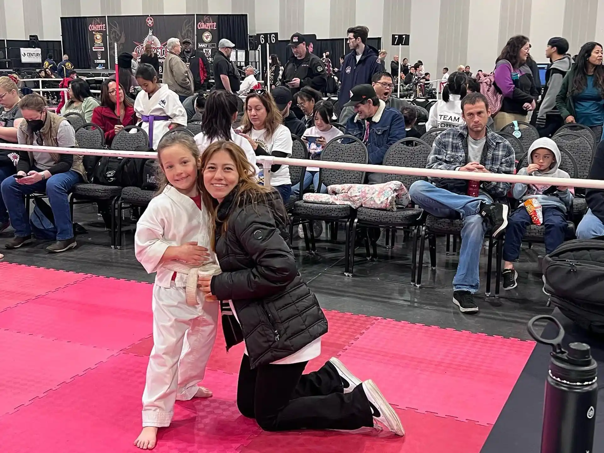 a person and a girl posing for a picture in front of a crowd