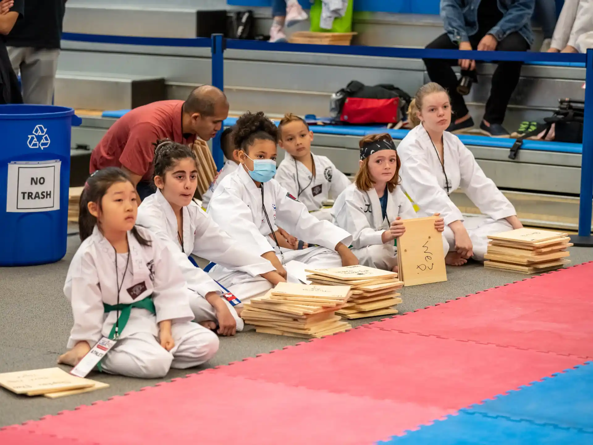 a group of people in white uniforms sitting on a mat
