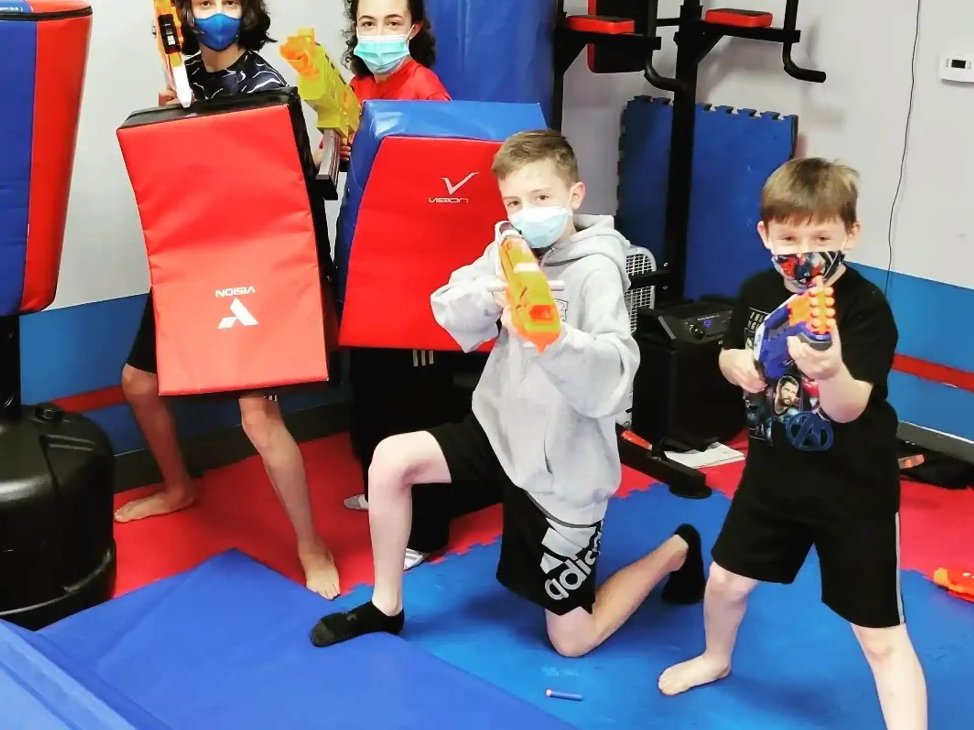 a group of children wearing masks and holding objects