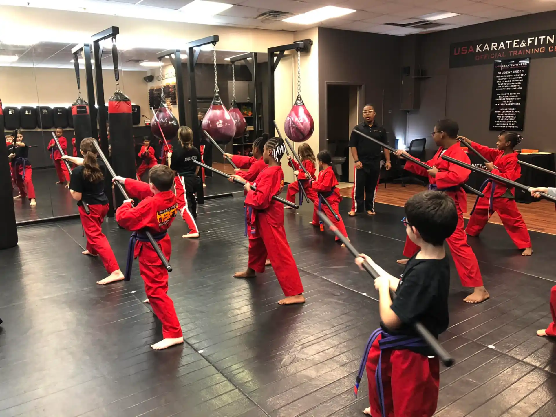 a group of people in red uniforms holding red and black balloons