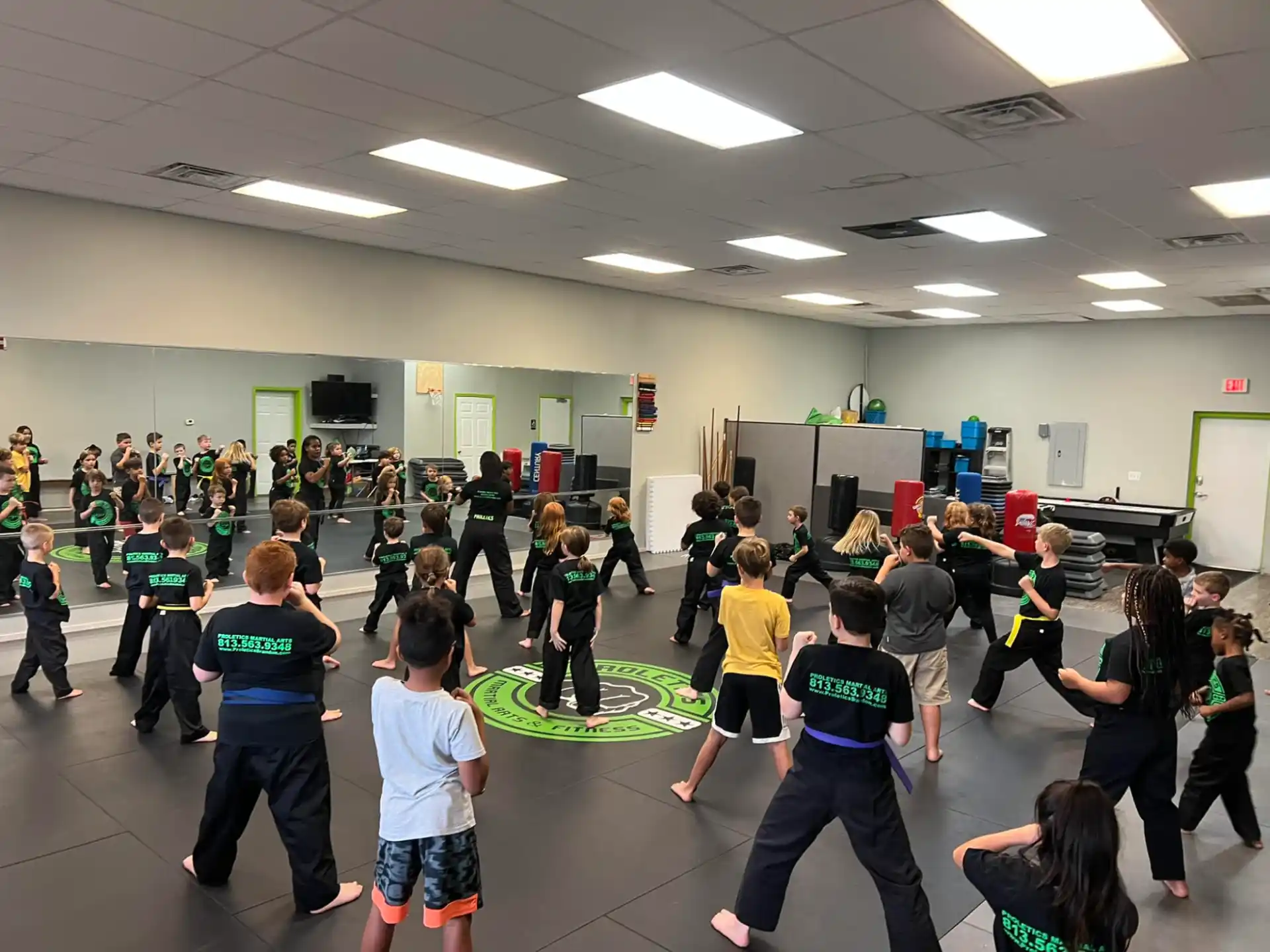 a group of people dancing in a room with a green wall and white walls