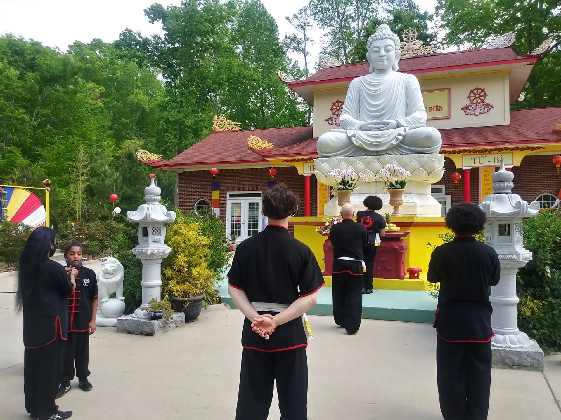 a group of people in uniform standing in front of a statue