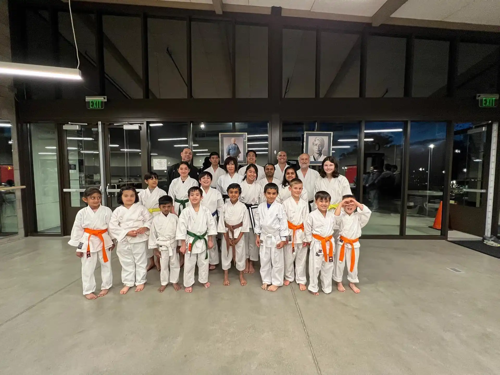 a group of people in white karate uniforms posing for a photo