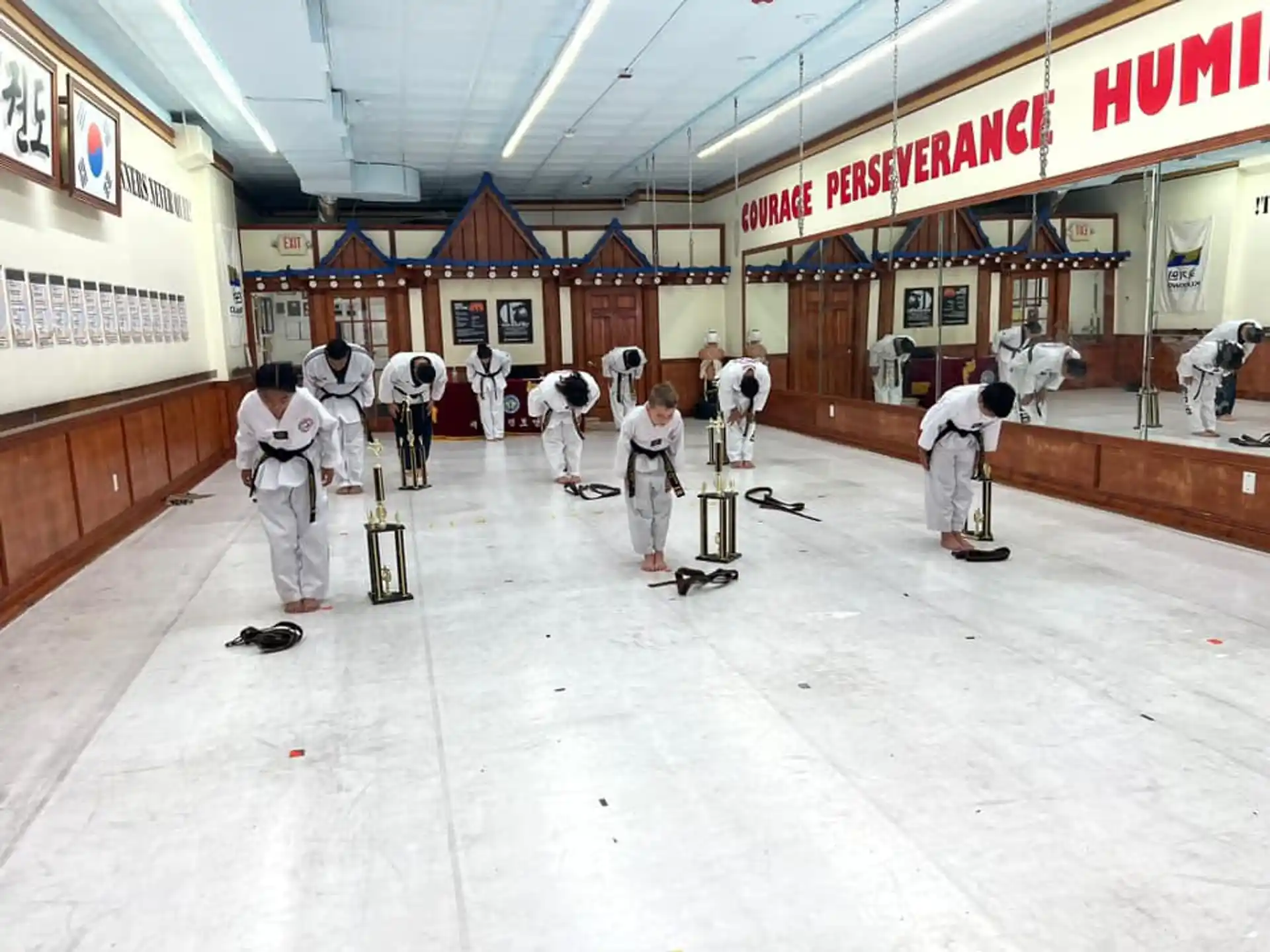 a group of people in white outfits in a room with a sign