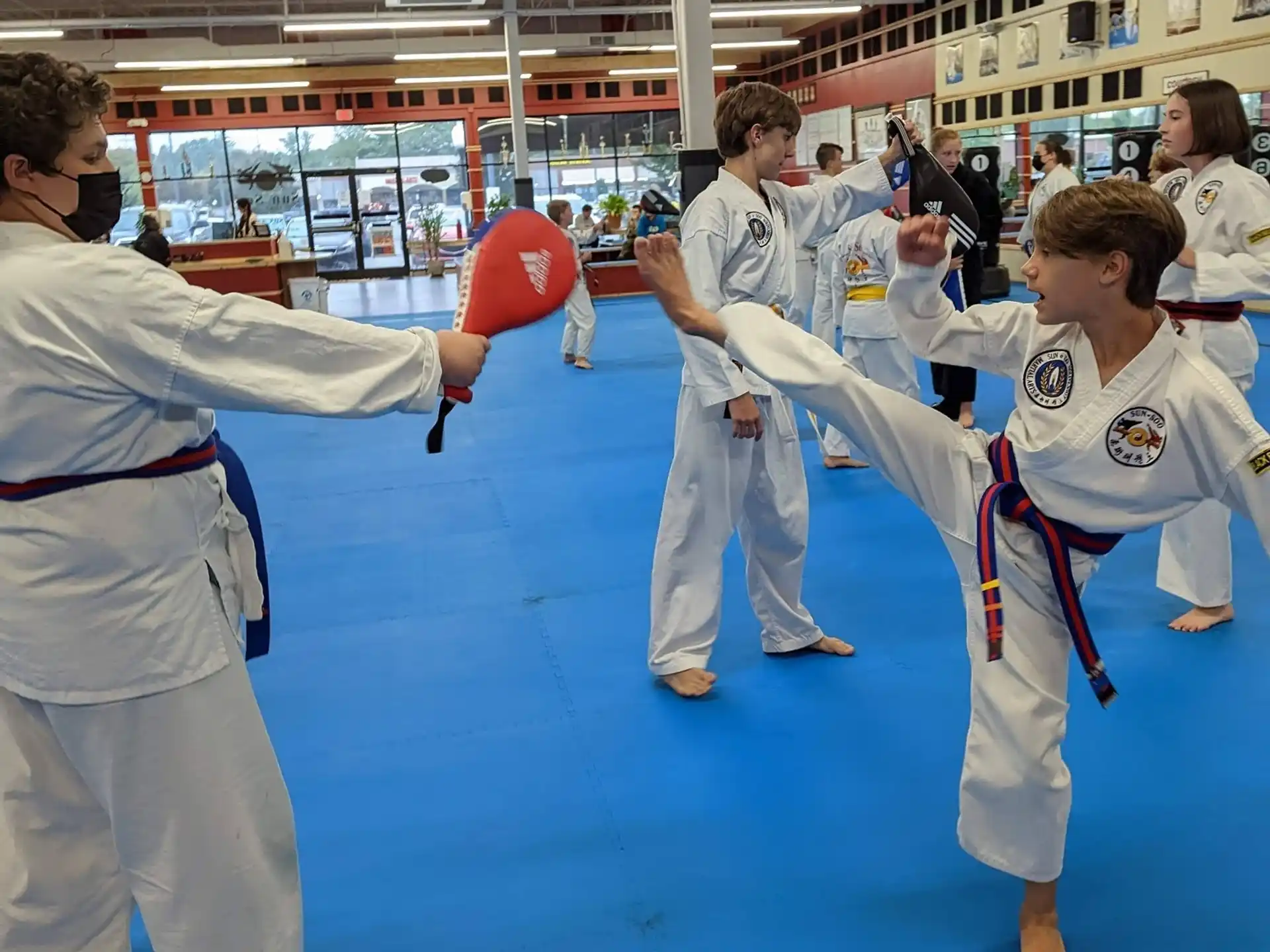a group of people in white karate uniforms holding a red object