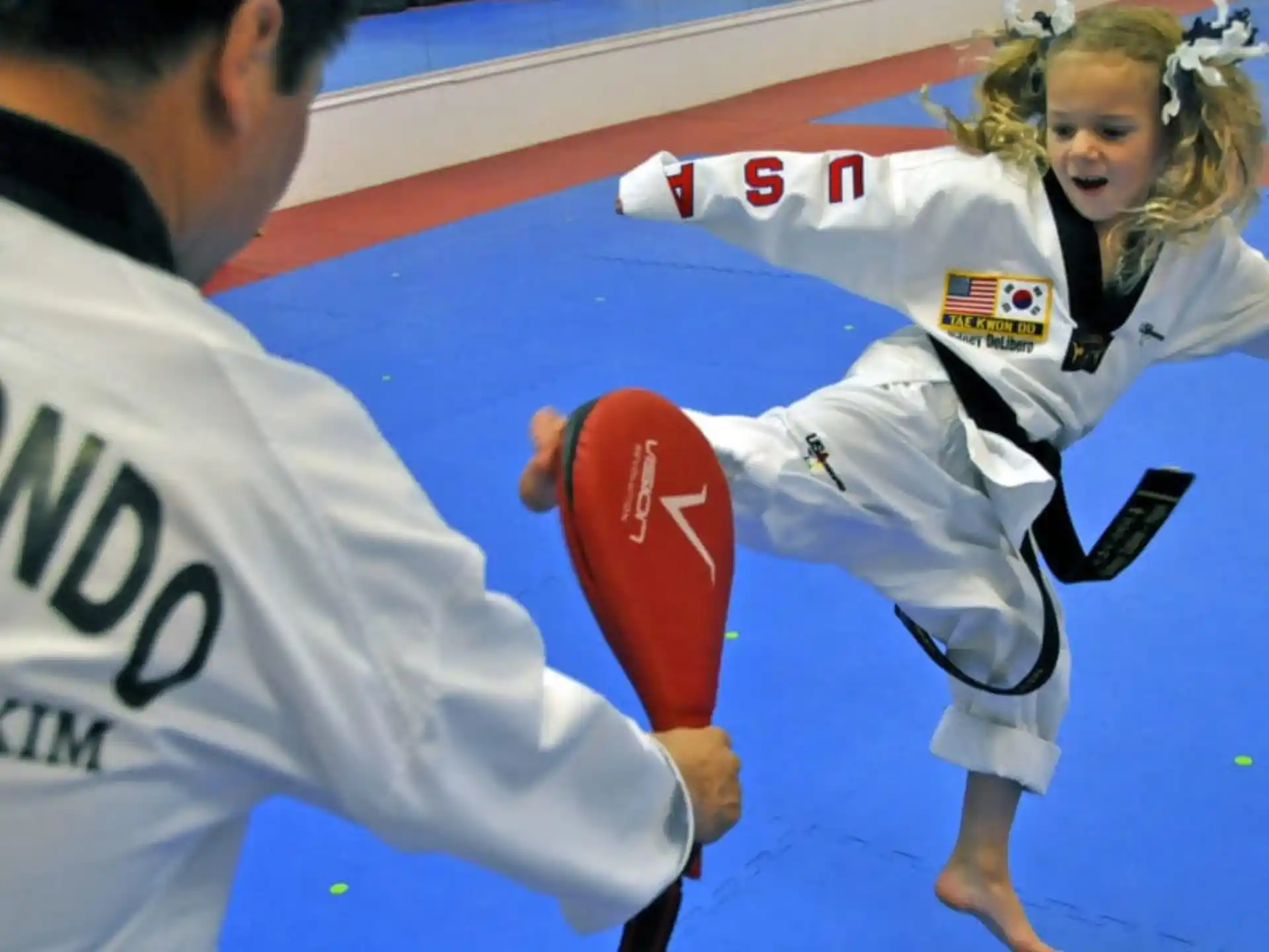 a woman in a white uniform kicking a man in a white uniform