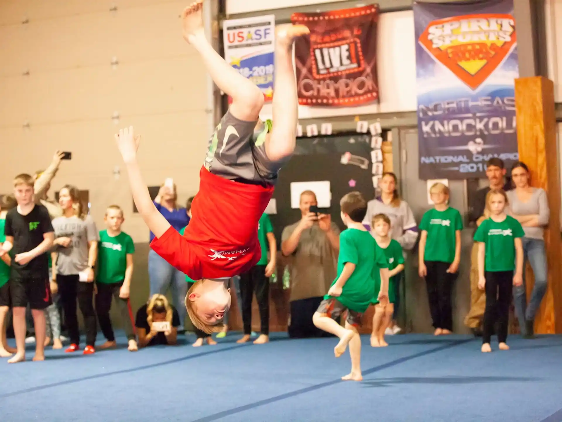 a person doing a handstand in front of a group of children
