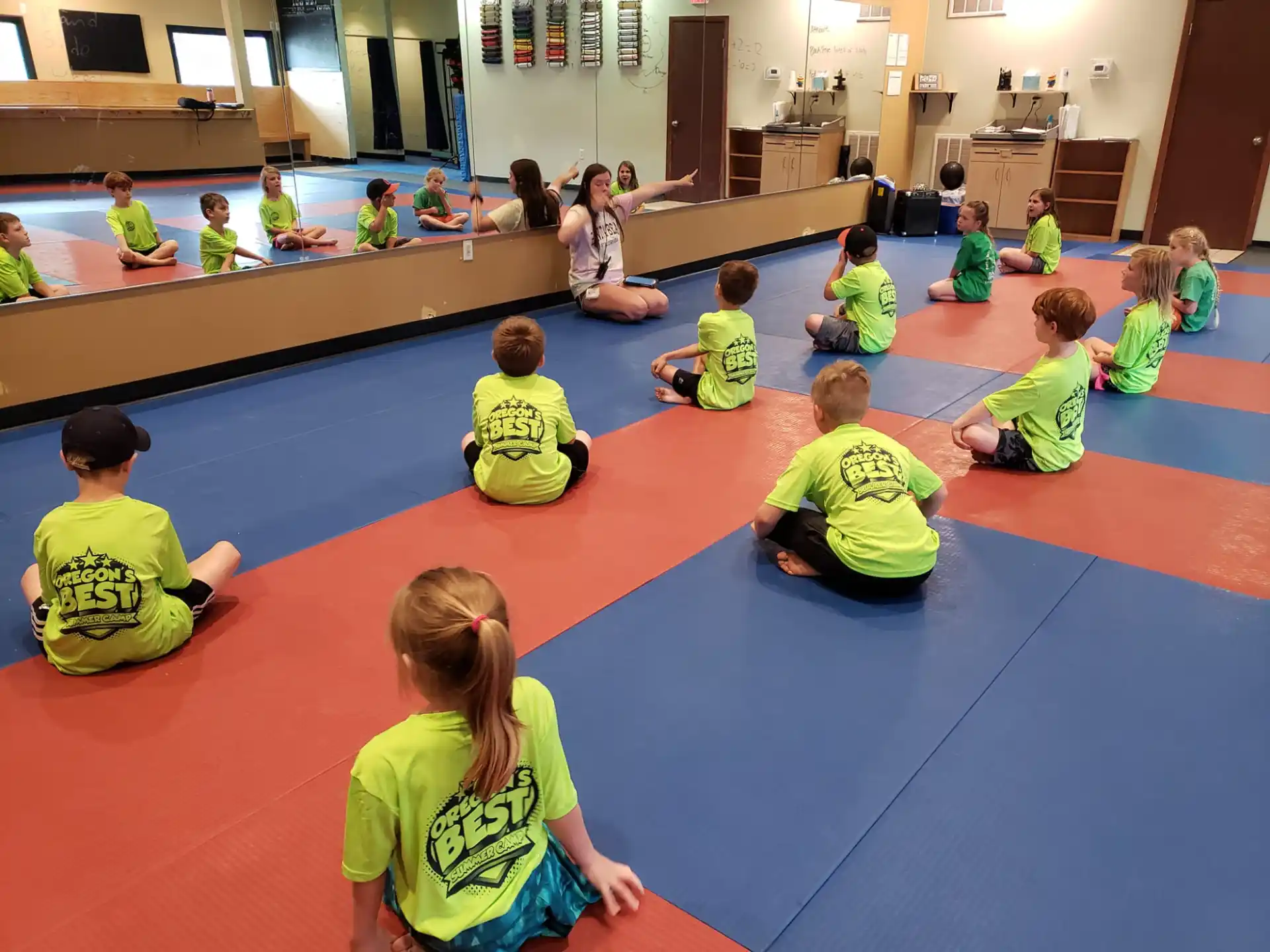 a group of children sitting on the floor in a classroom