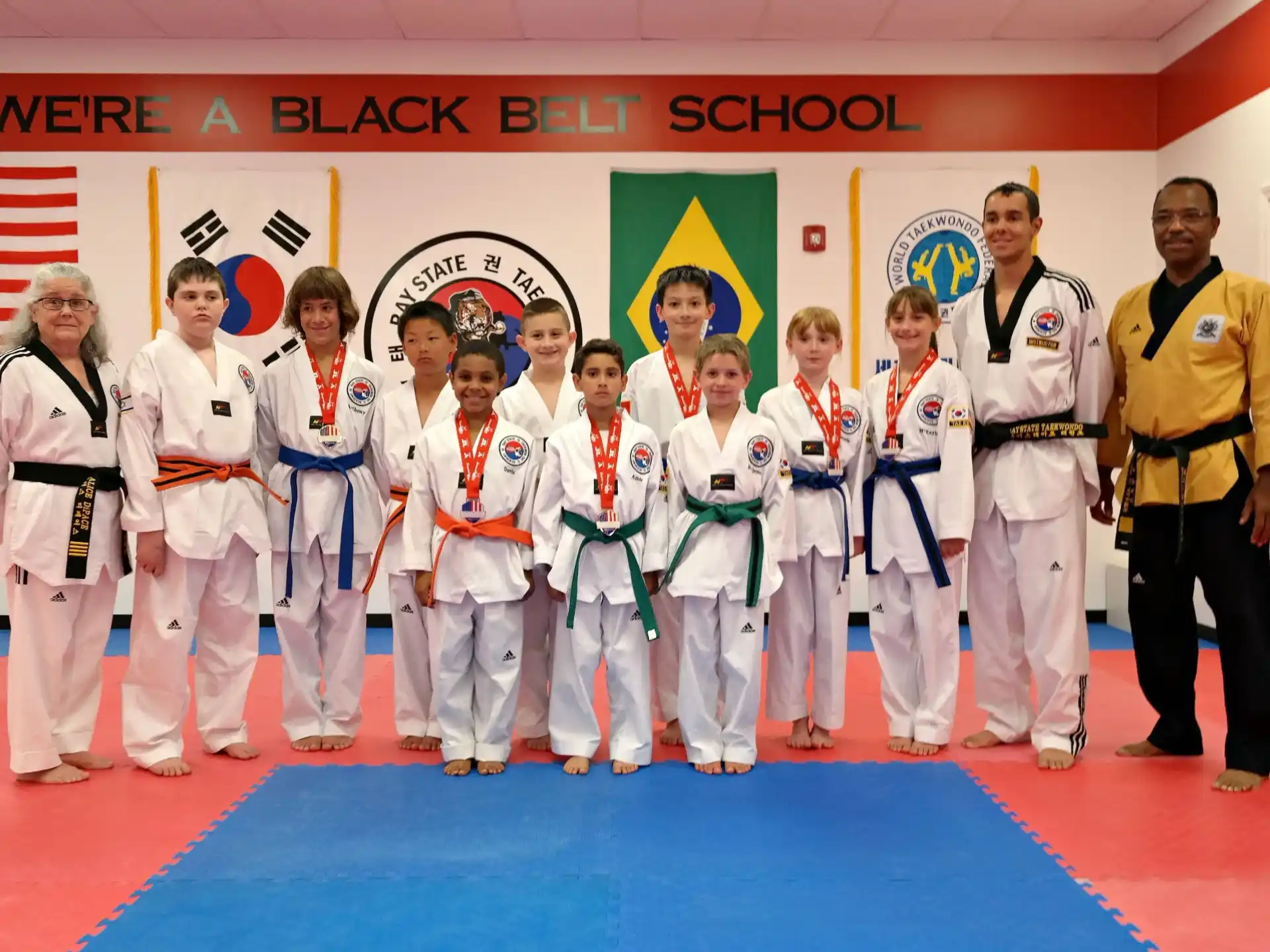 a group of people in white karate uniforms standing on a blue mat
