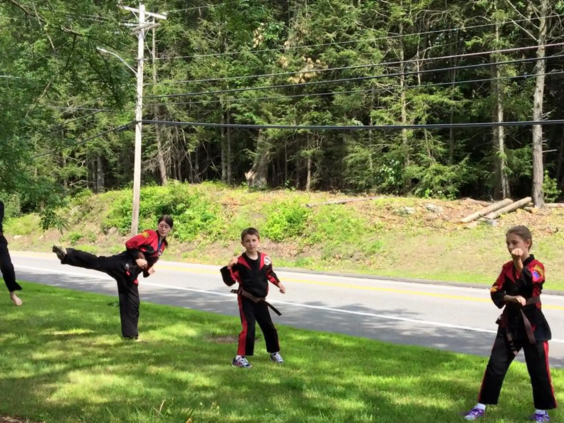 a group of people running on a road with trees in the background