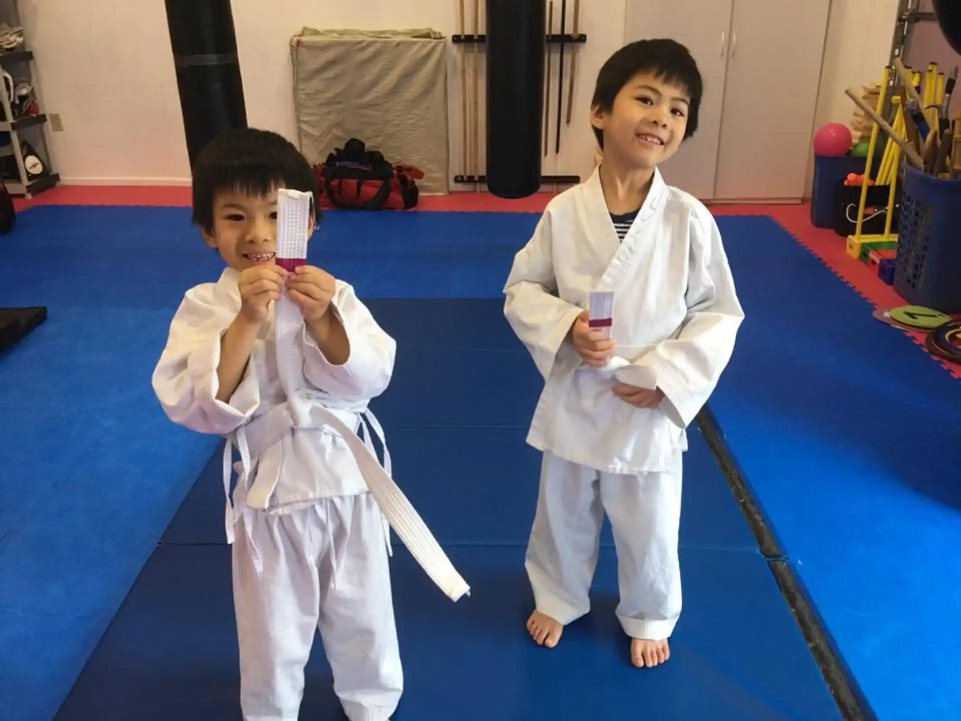 a couple of kids in karate uniforms