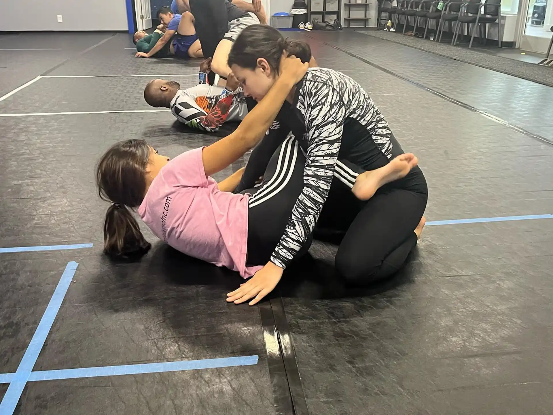 a person kneeling down to touch a girl's head