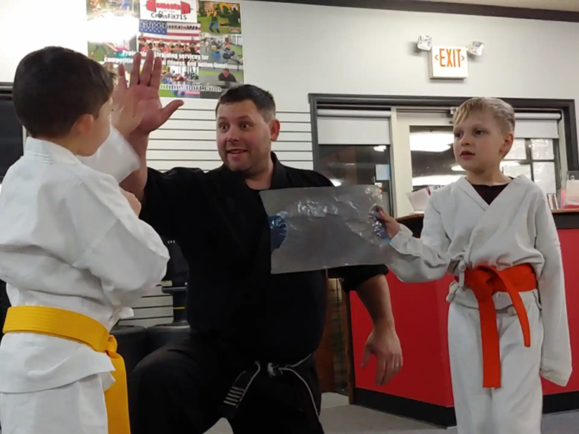 a person in a garment with a boy in a karate uniform