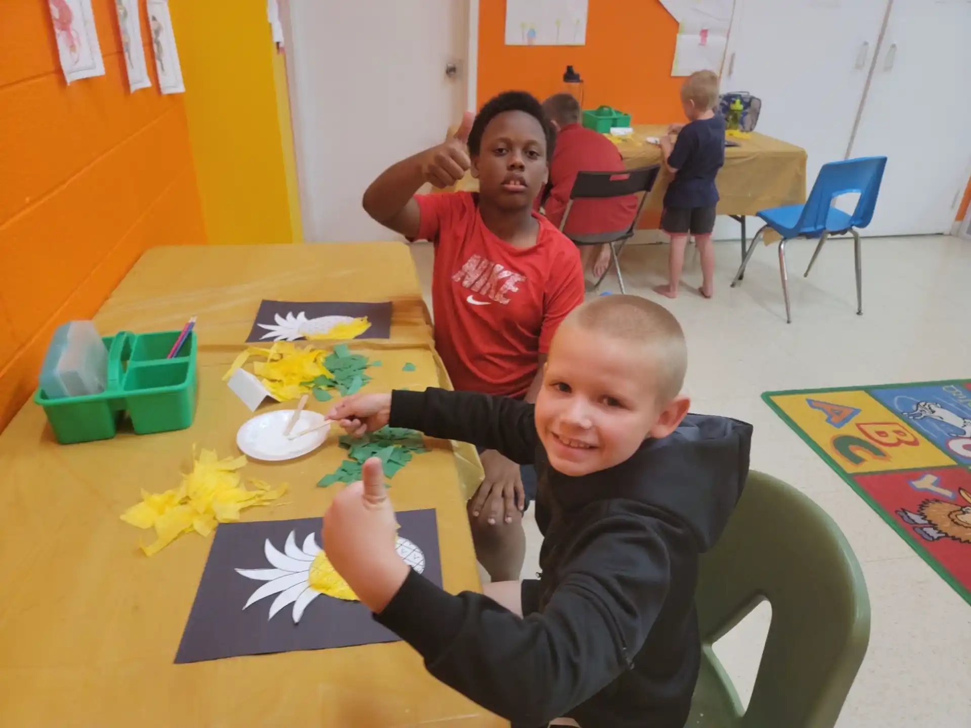 a person and a boy sitting at a table with a yellow tablecloth