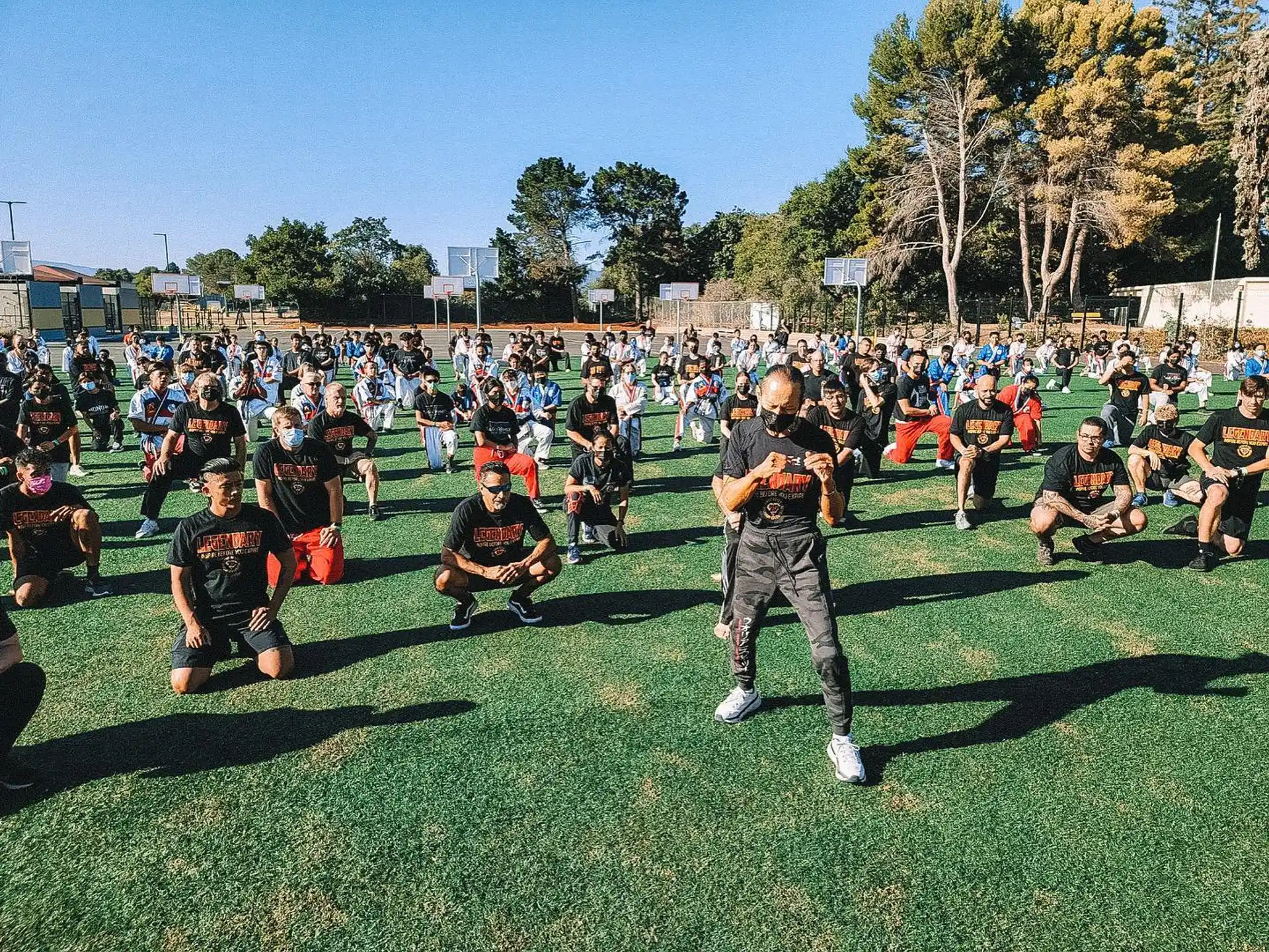 a person walking on a field with a crowd watching