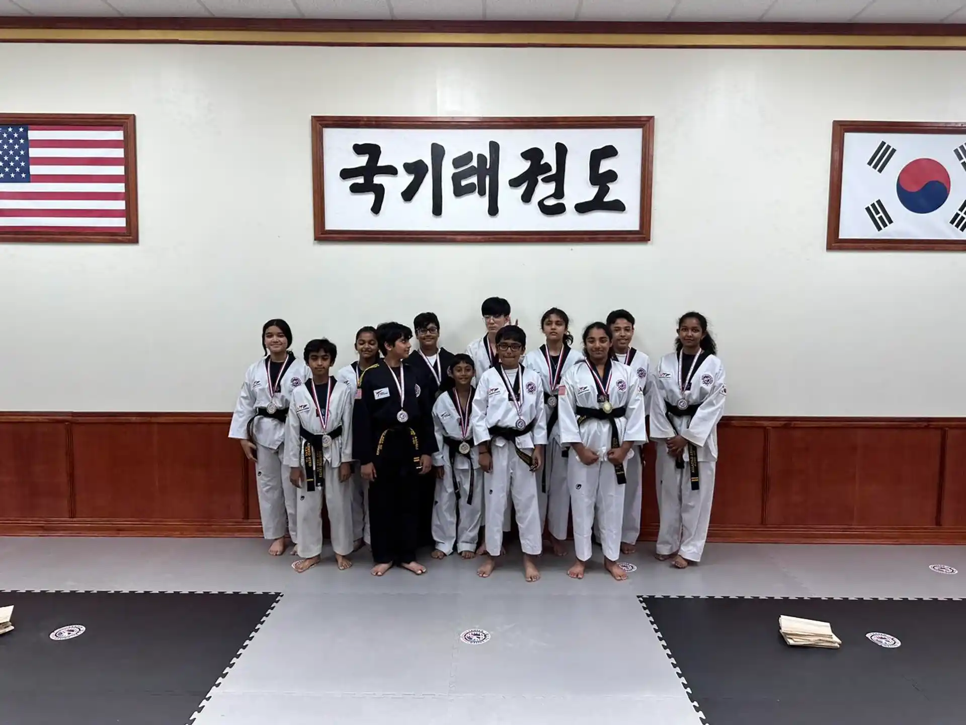 a group of people in white karate uniforms posing for a photo