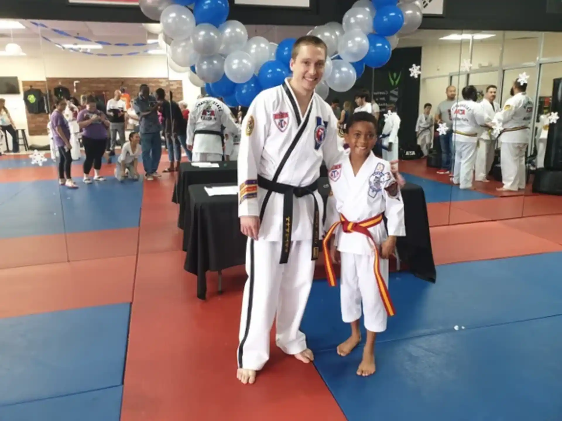 a man and a woman in karate uniforms standing on a red carpet