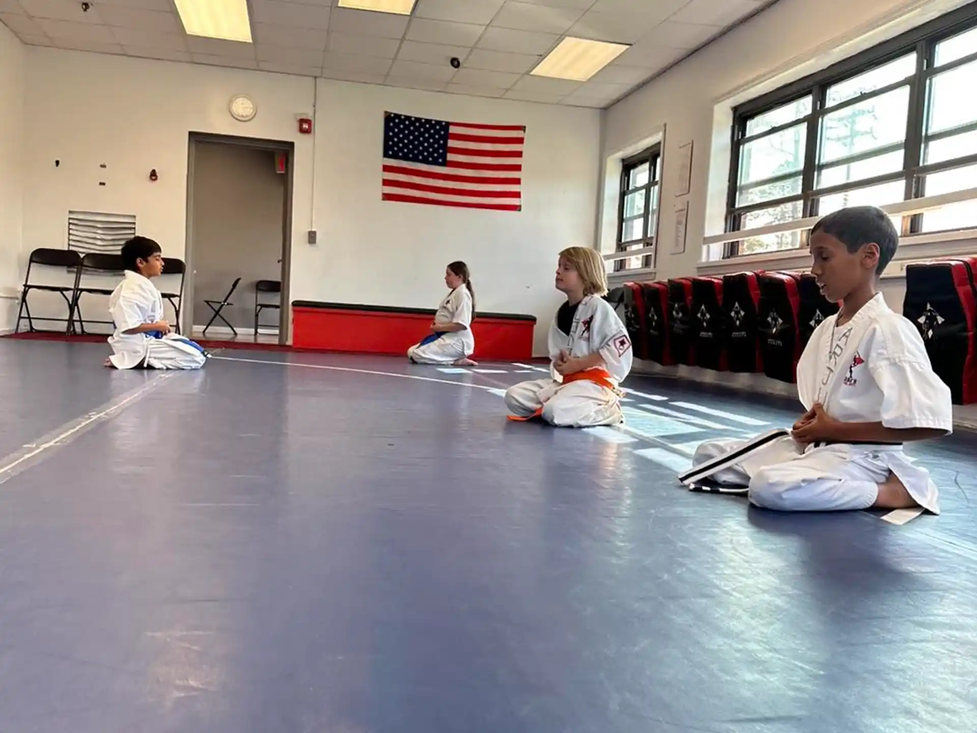 a group of people sitting in a room with a flag on the wall