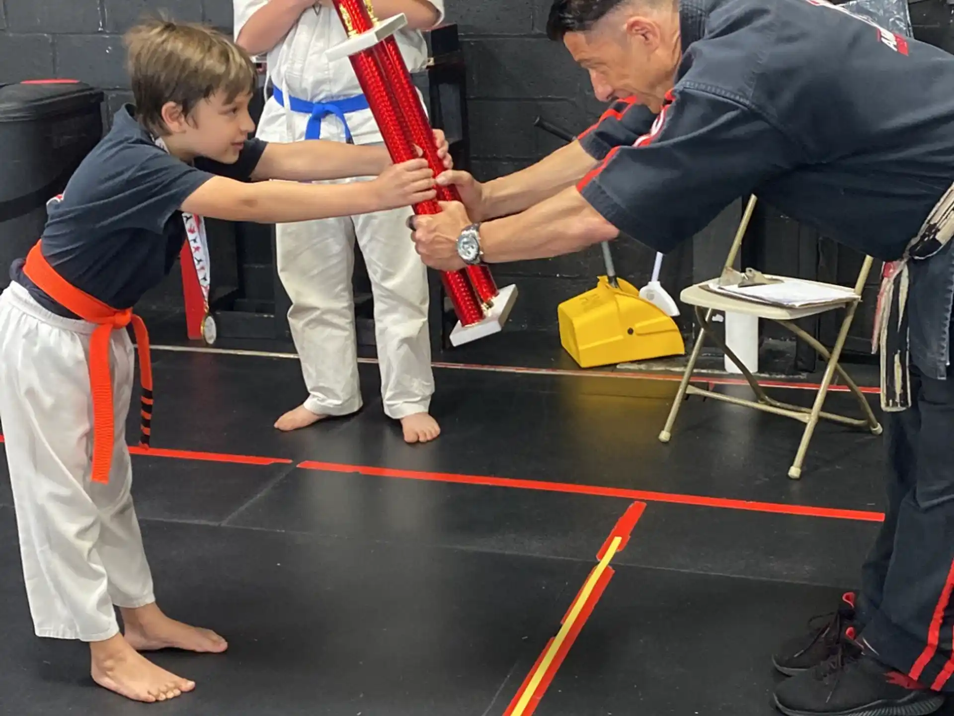 a person helping a boy with a bow and arrow