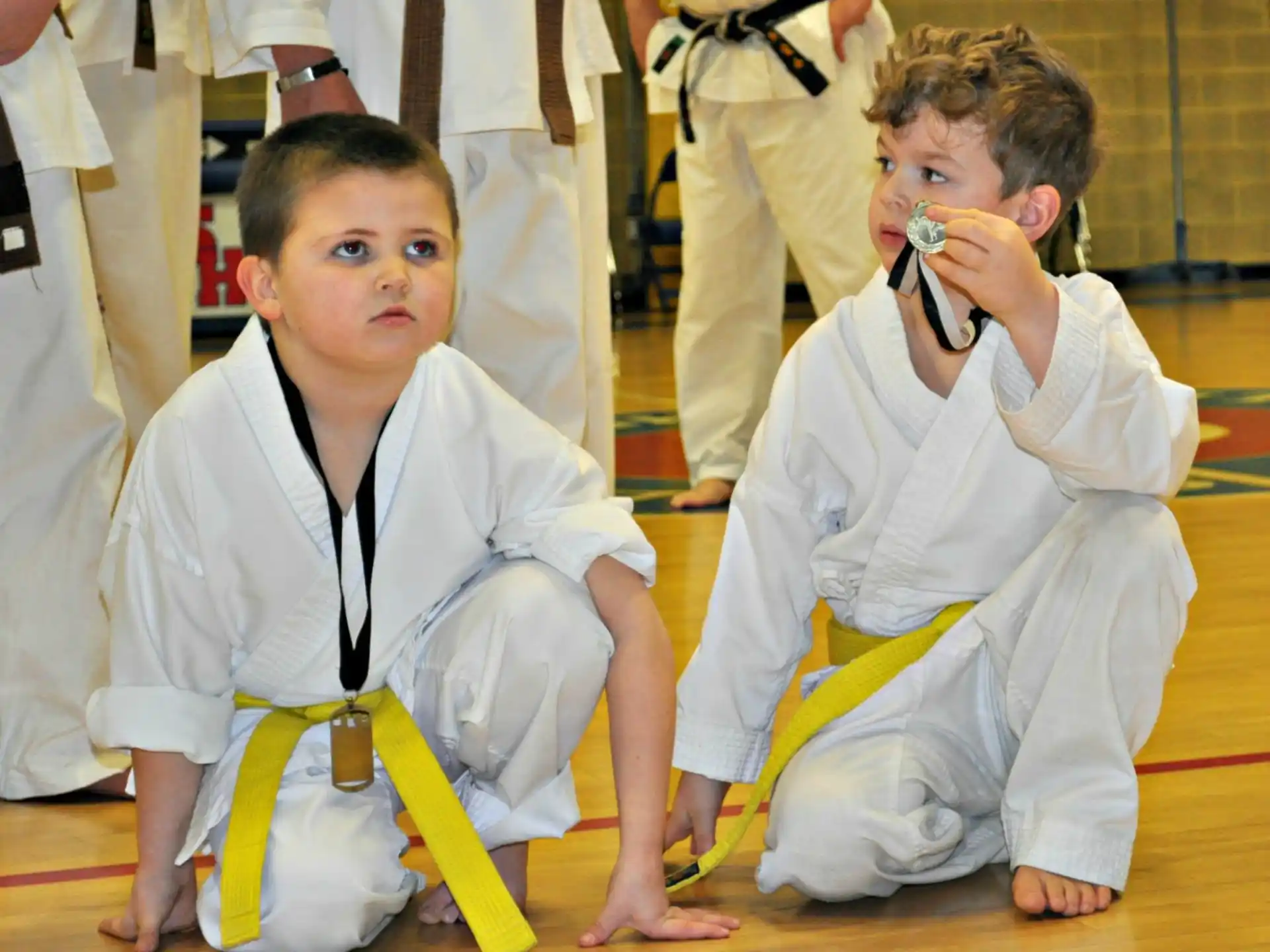 a couple of young boys in karate uniforms on the floor