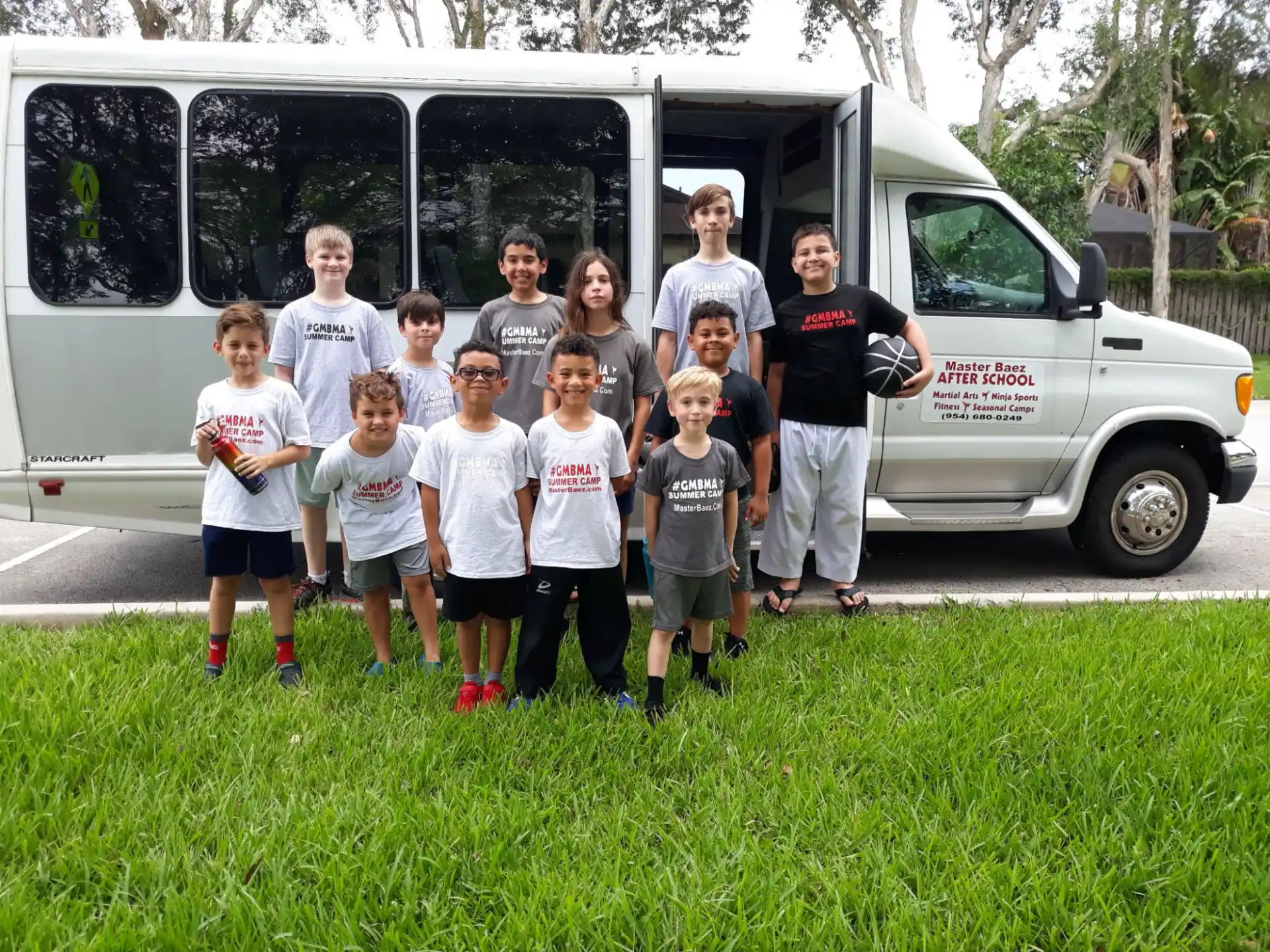 a group of people posing for a photo in front of a white van