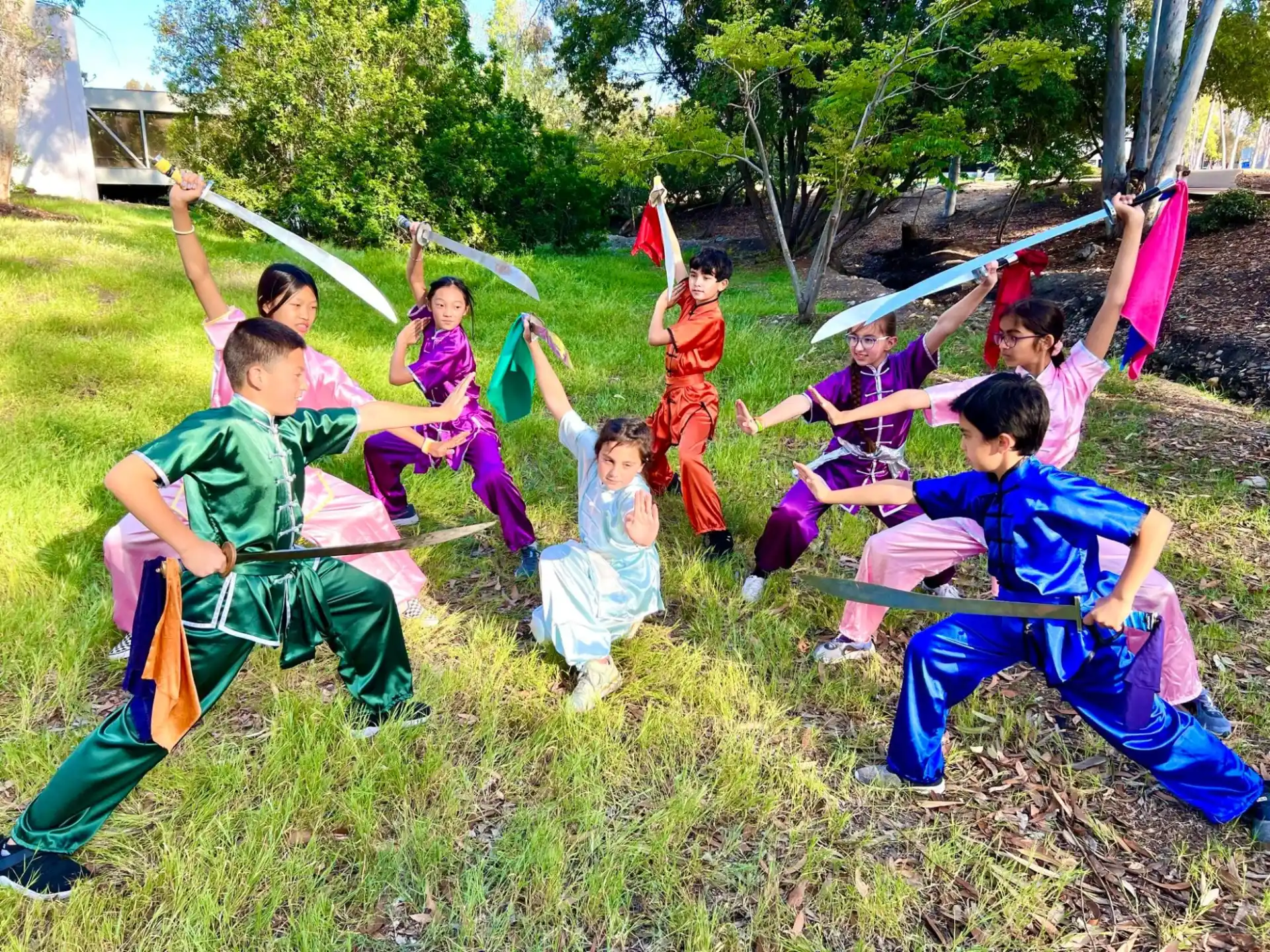 a group of people in clothing sitting on the grass