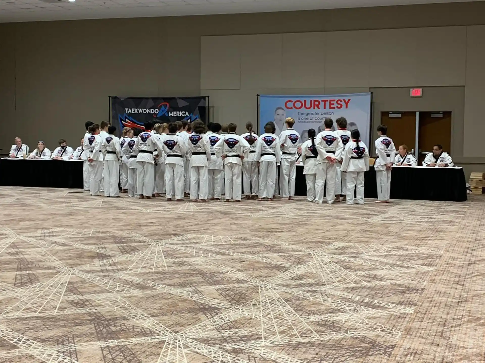 a group of people in white karate uniforms standing in a room