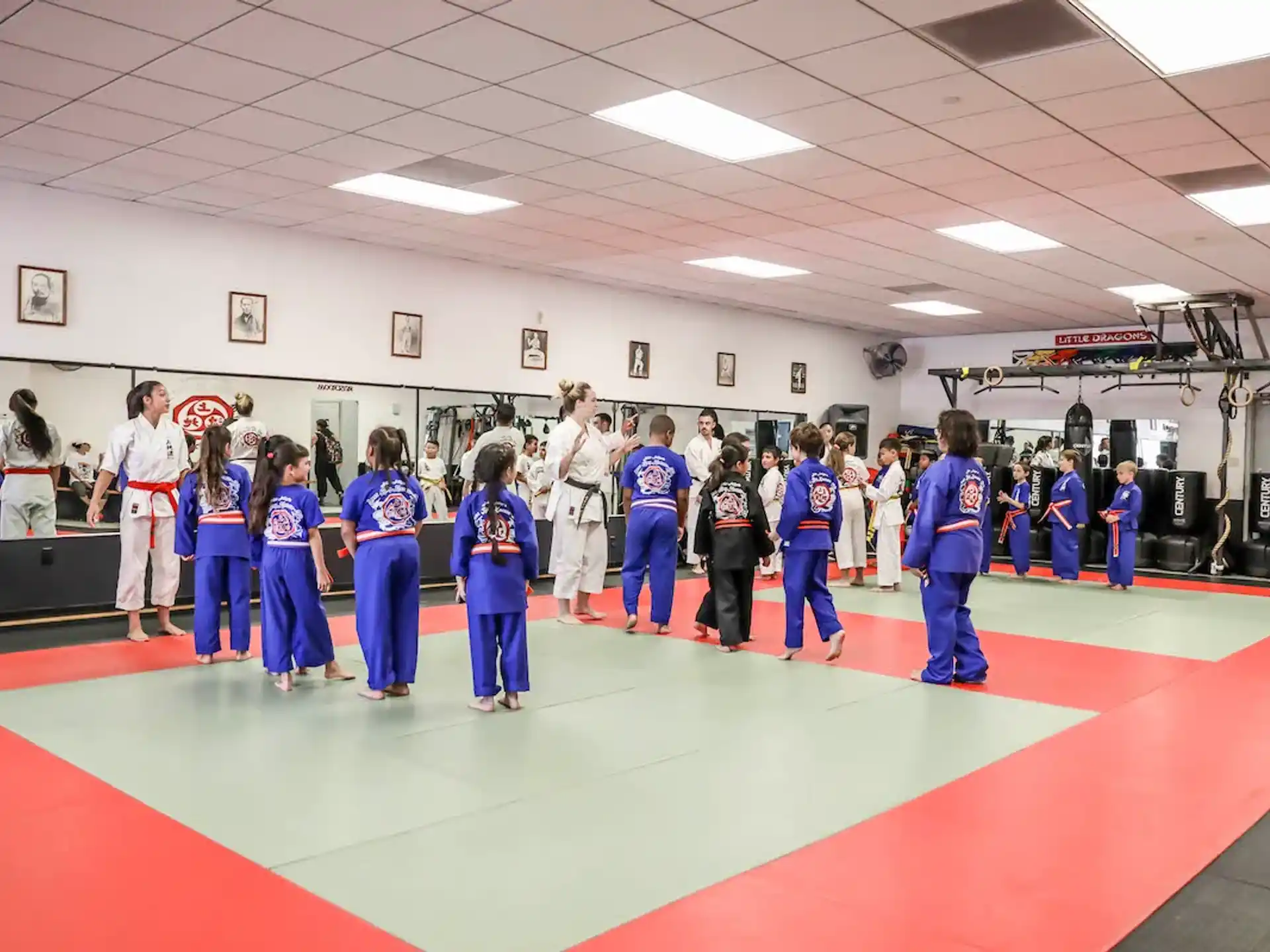 a group of people in blue karate uniforms standing on a red mat