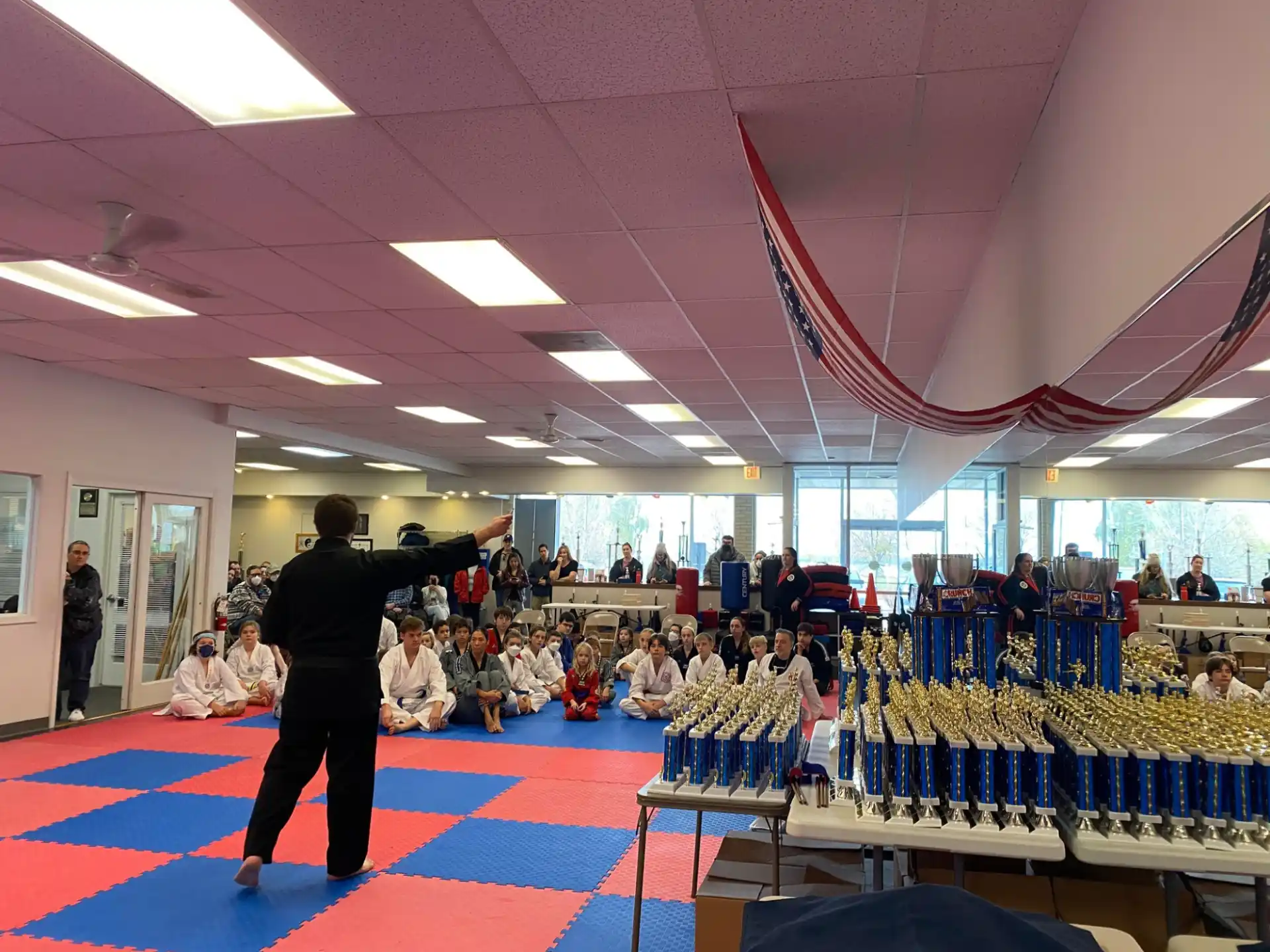 a group of people sitting in a room with a person standing in front of a large group of