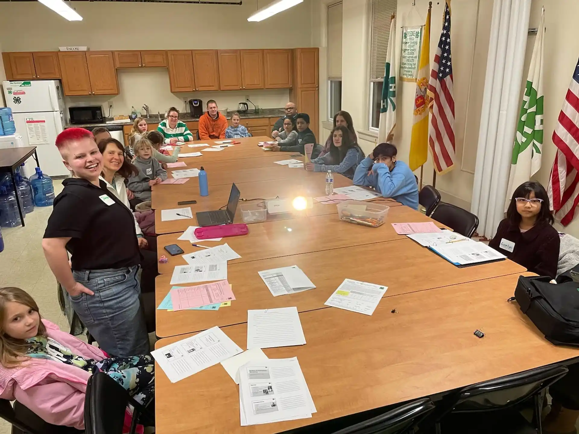 a group of people sitting around a table with papers on it