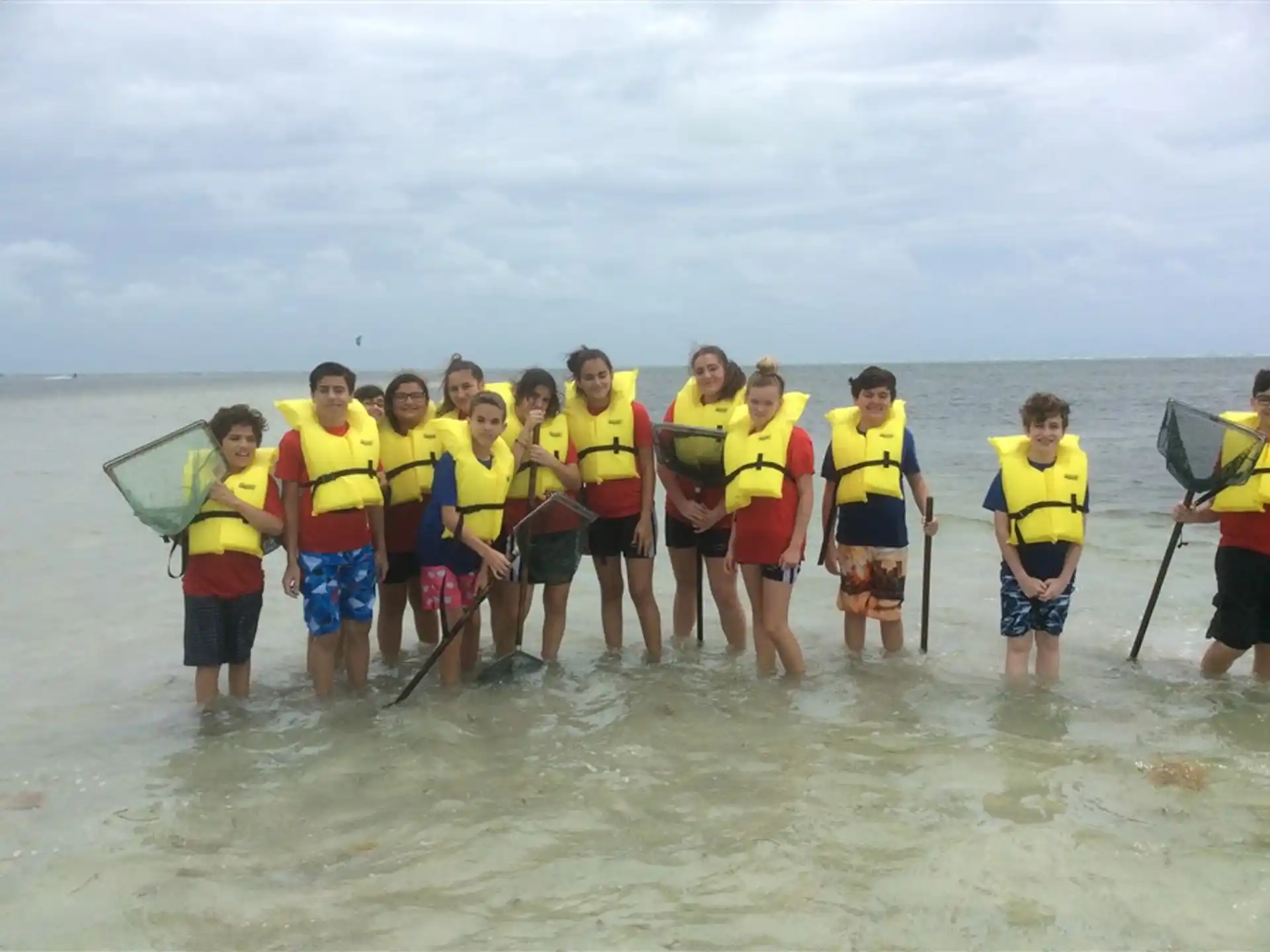 a group of people in life jackets standing in water