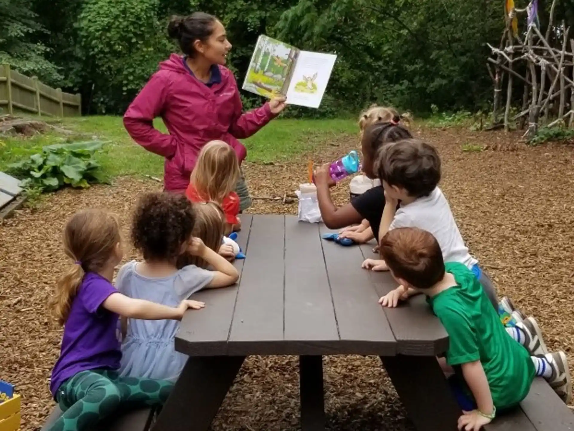 a person teaching children how to play a game
