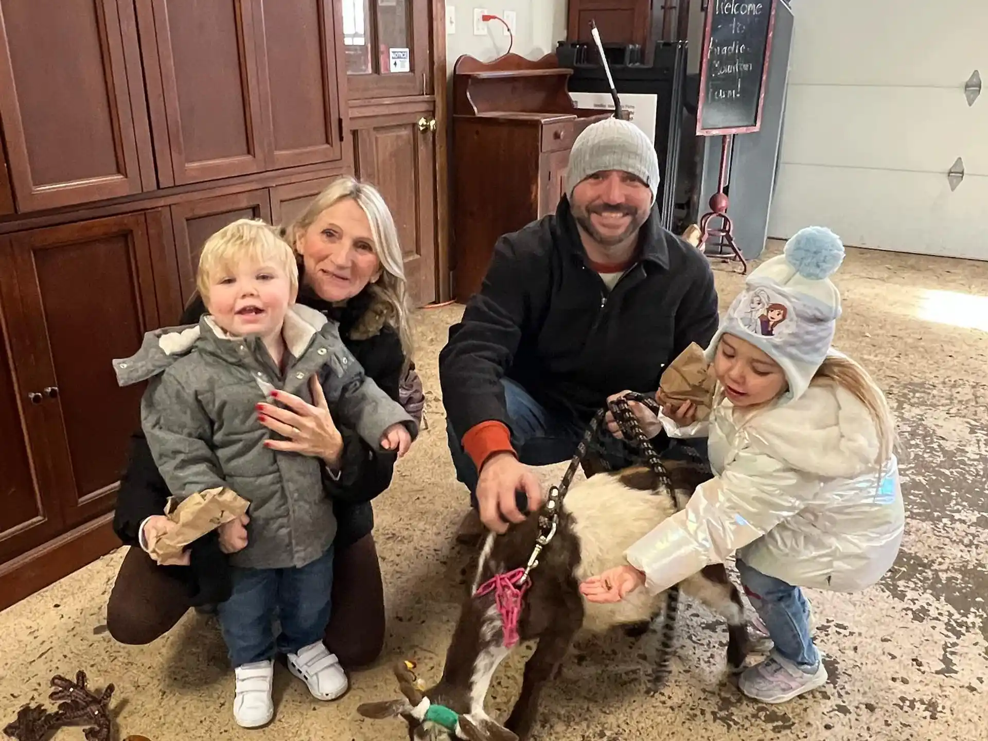 a person and a couple of children with a dog in a room