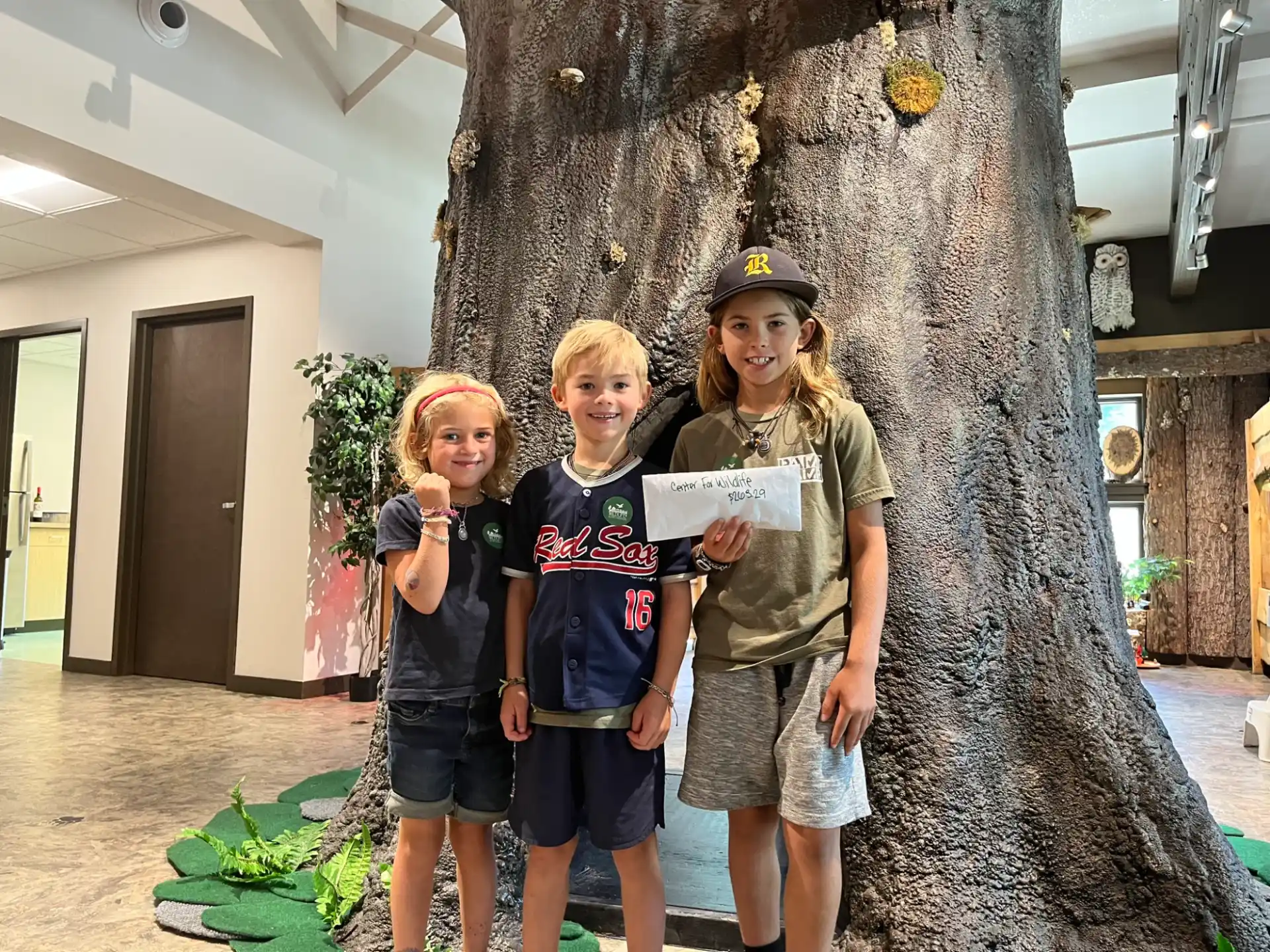 a group of kids posing for a picture next to a tree