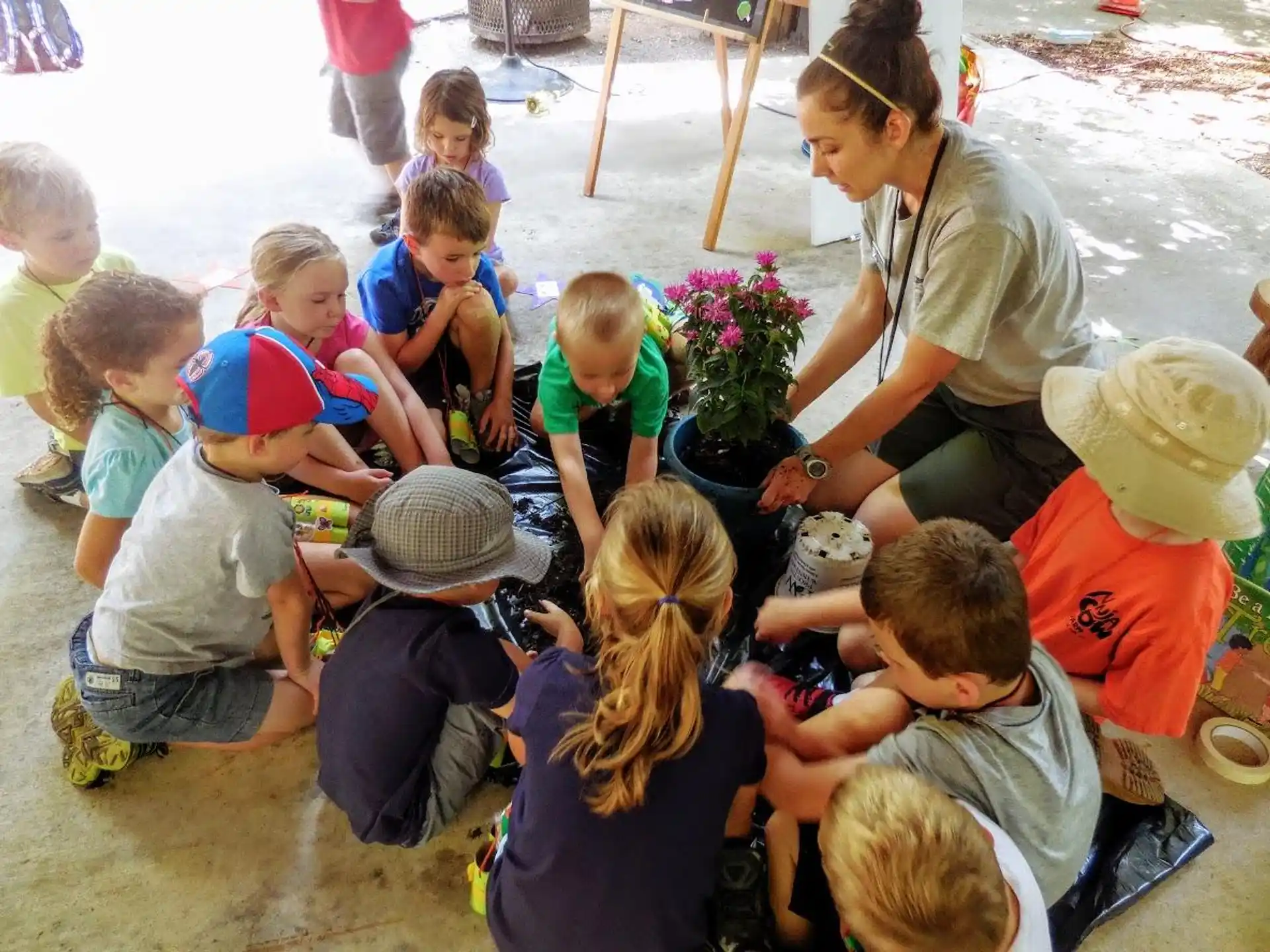a person kneeling down to pet a group of children