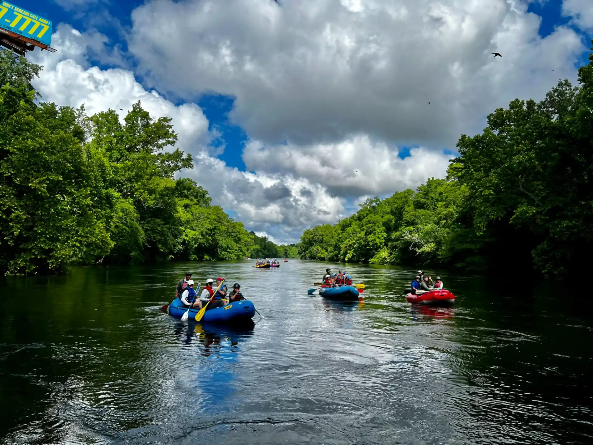 a group of people in a row boat on a river