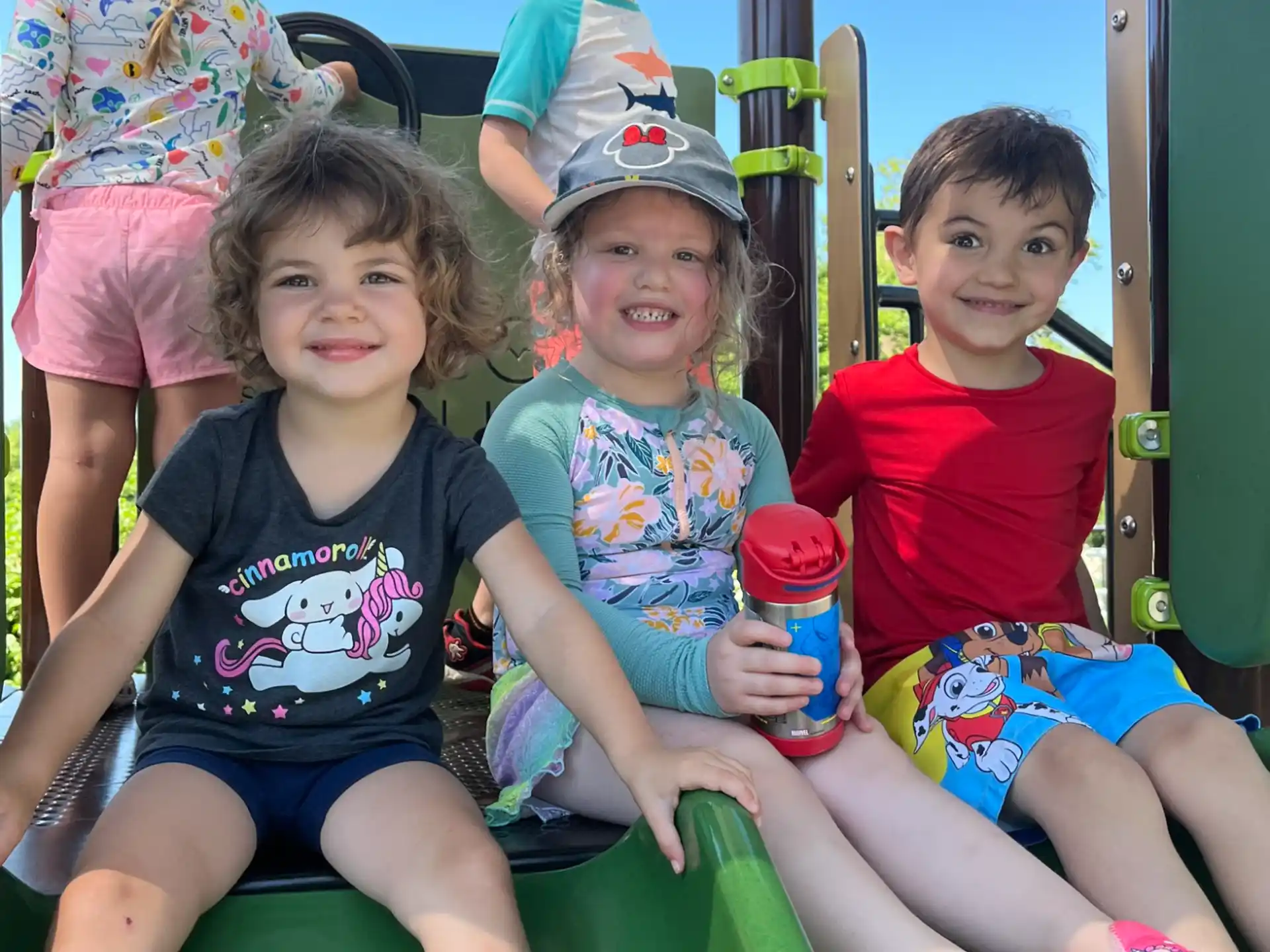 a group of children sitting on a playground ride