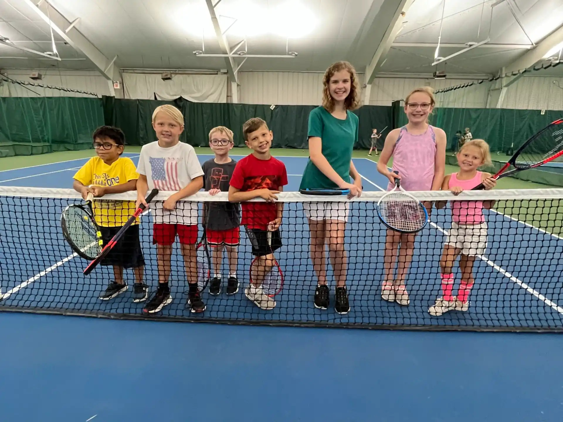a group of kids holding tennis rackets